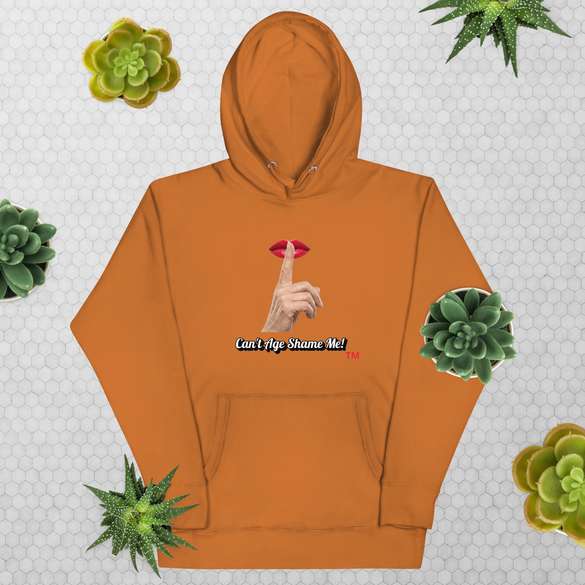 Adobe hoodie with graphic design and text, Can’t Age Shame Me!, on a patterned background with succulents