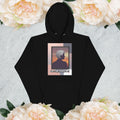 Black hoodie with a graphic design of a woman with gray hair on a light gray background with flowers

