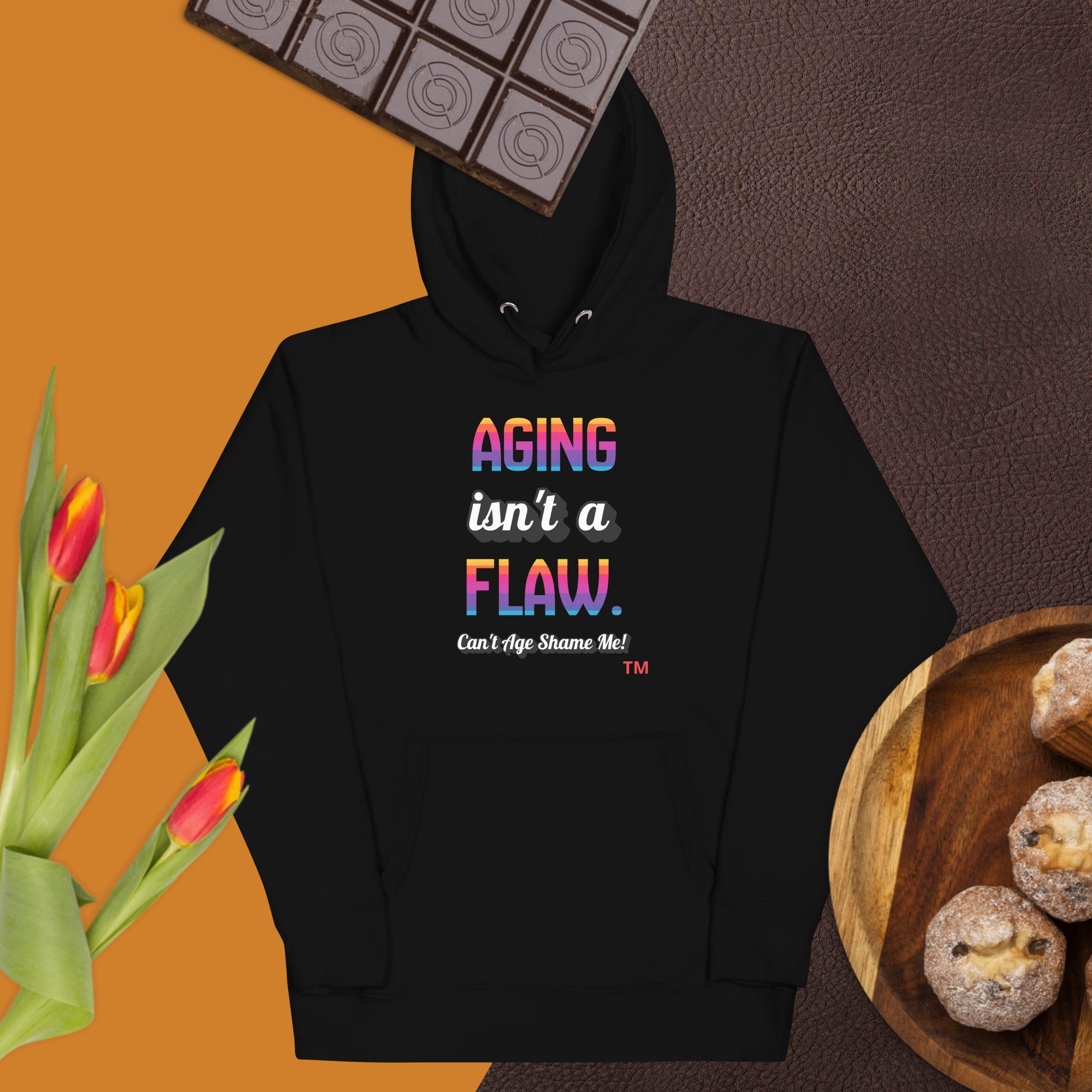 Black hoodie with colorful text on a brown background with chocolate, tulips, and cookies.
