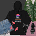 Black hoodie with colorful text and graphics, paired with denim shorts and black sandals on a dark background.