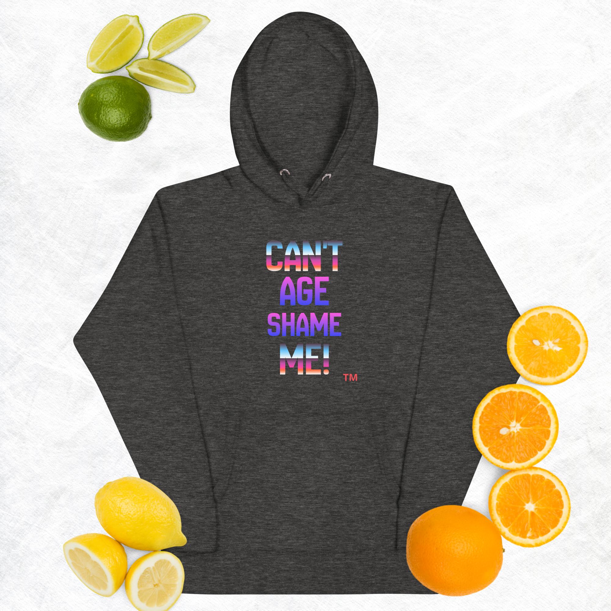 Dark gray hoodie with colorful text 'CAN'T AGE SHAME ME!' surrounded by fruits on a light background