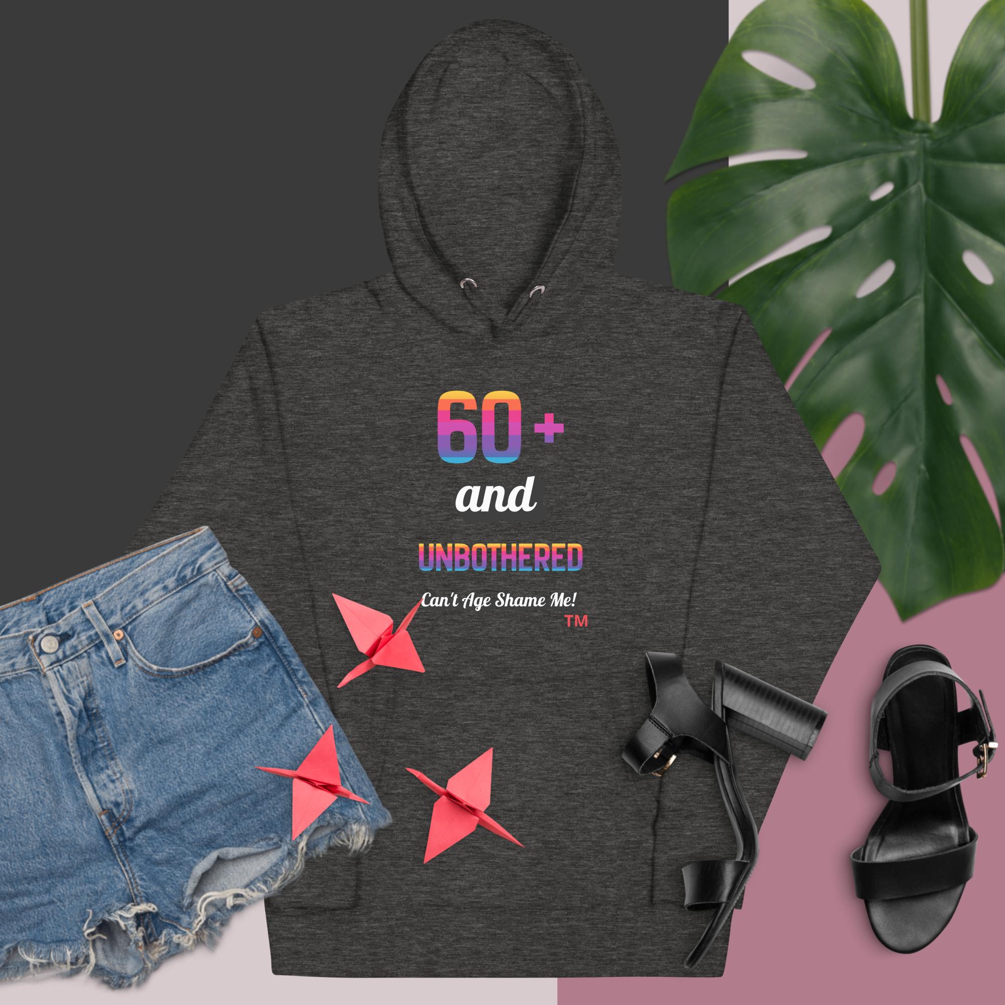 Dark gray hoodie with colorful text and graphics, paired with denim shorts and black sandals on a dark background.
