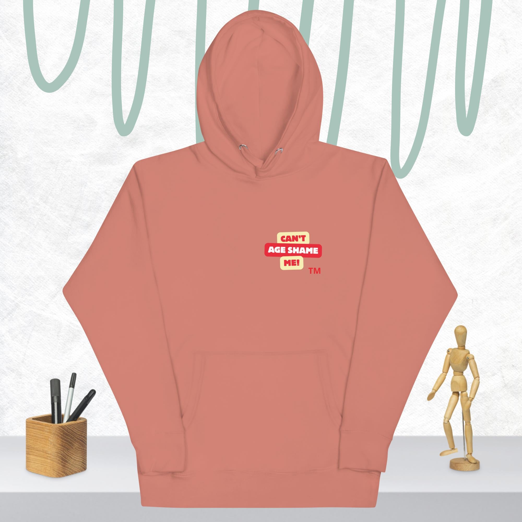 Dusty Rose hoodie with a red and white logo text 'CAN'T AGE SHAME ME! on a light gray background