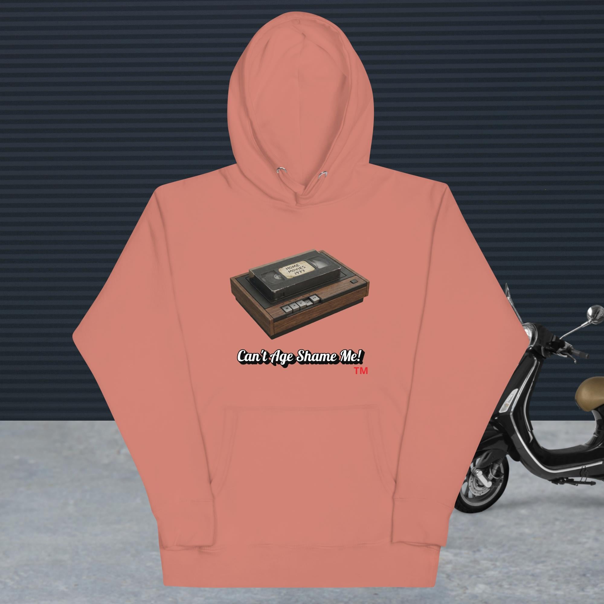 dusty rose hoodie with a design of vhs recorder and tape