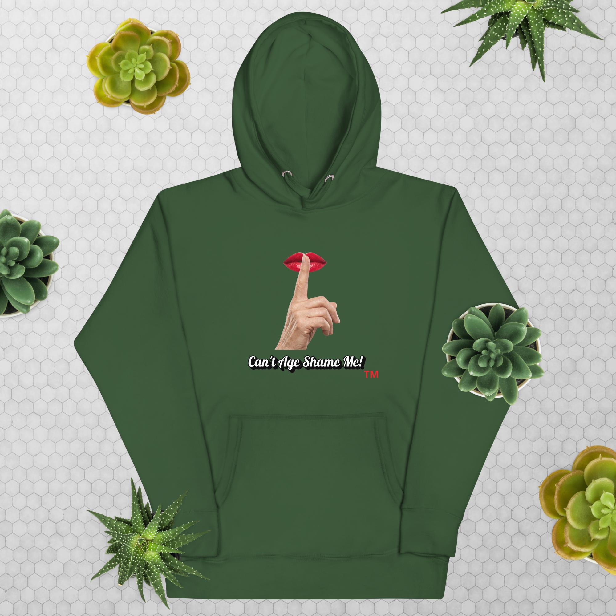 Forest Green hoodie with graphic design and text, Can’t Age Shame Me!, on a patterned background with succulents