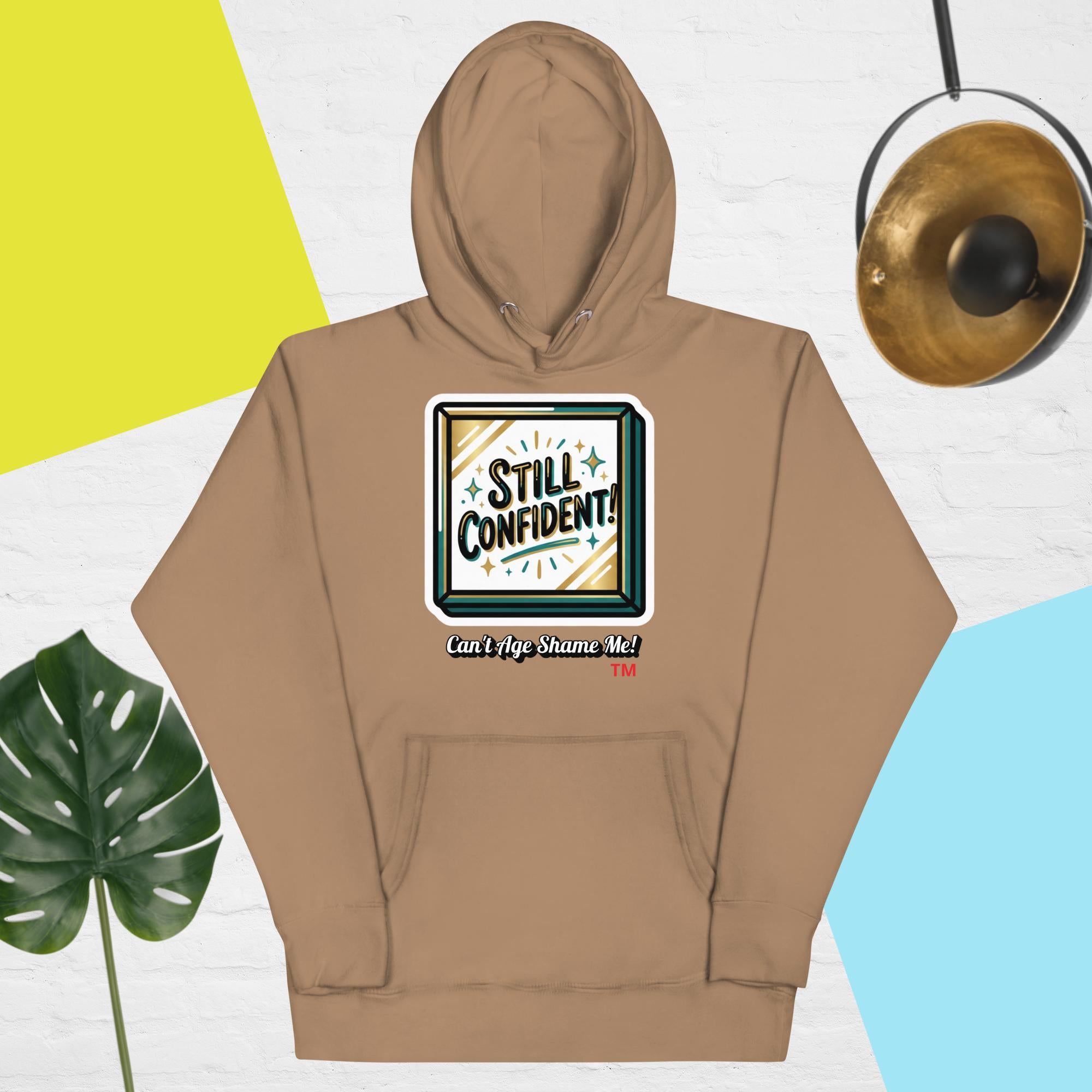 Latte hoodie with 'Still Confident' graphic on a colorful background