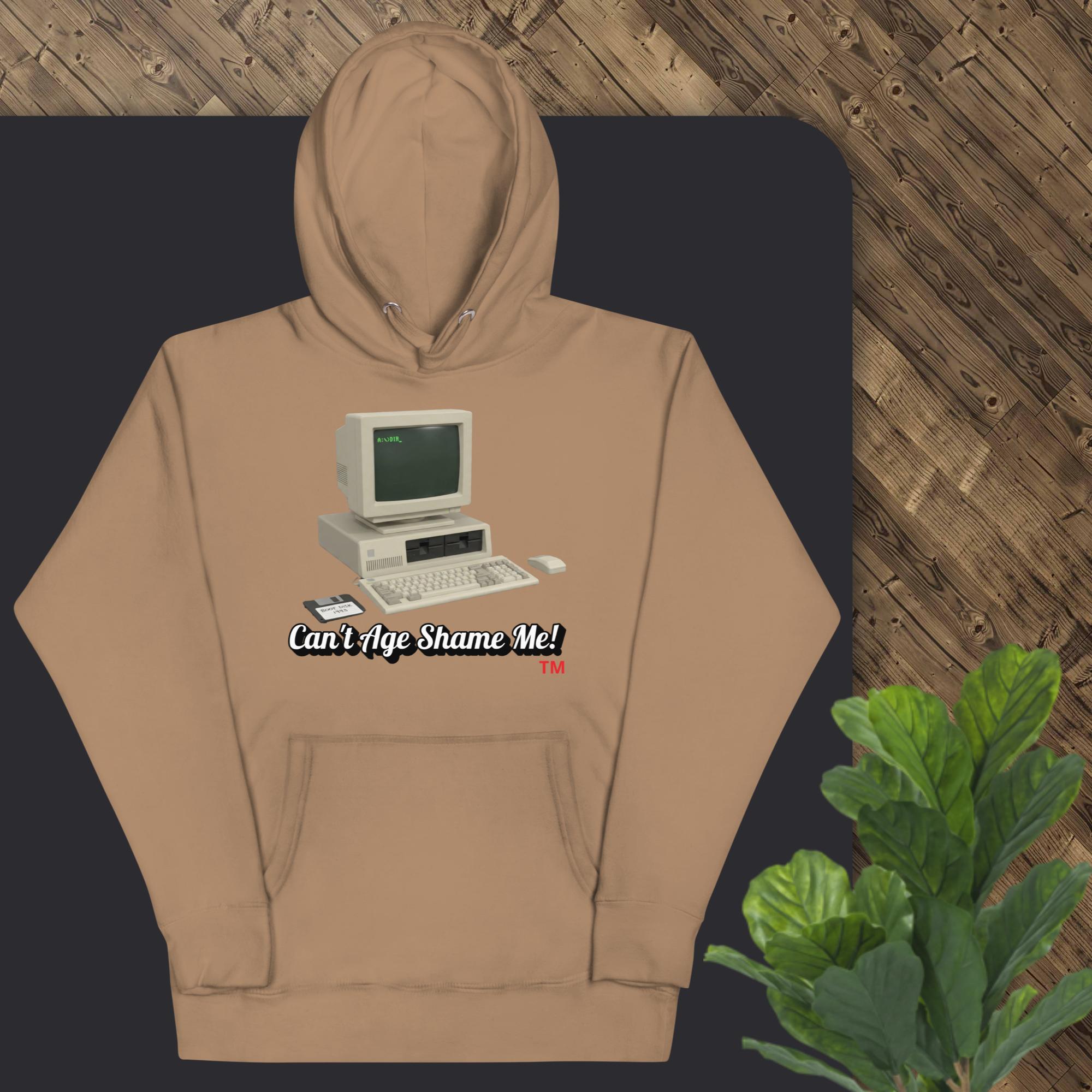 latte  hoodie with vintage computer graphic and text on a dark surface with a wooden background