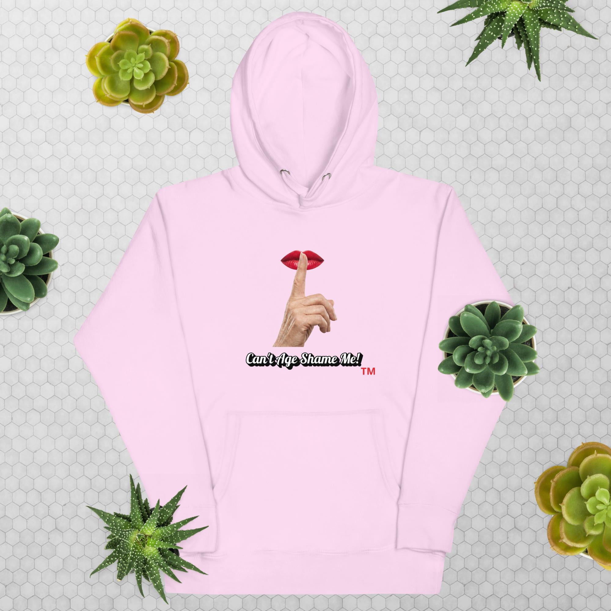 Lavender hoodie with graphic design and text, Can’t Age Shame Me!, on a patterned background with succulents