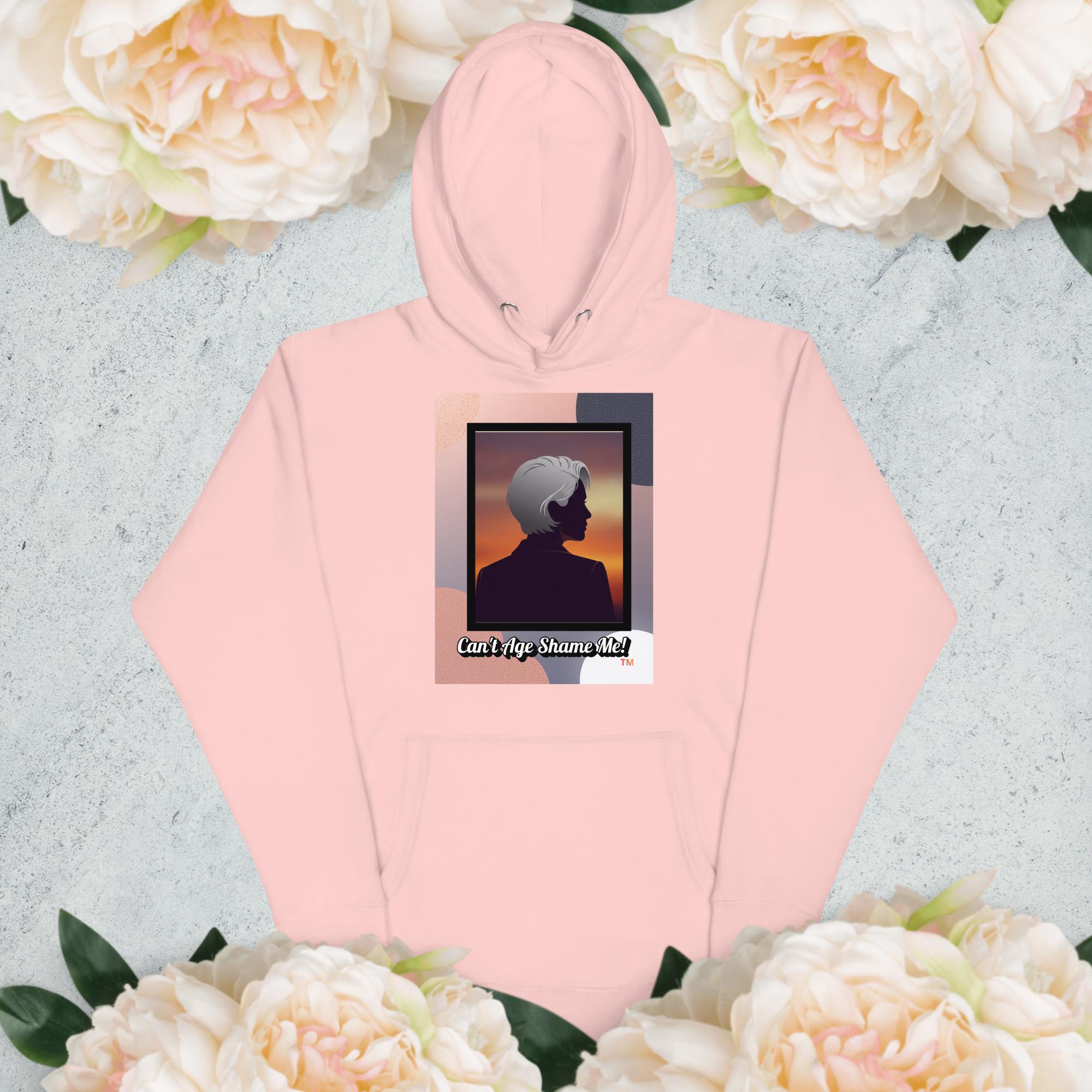 Pink hoodie with a graphic design of a woman with gray hair on a light gray background with flowers

