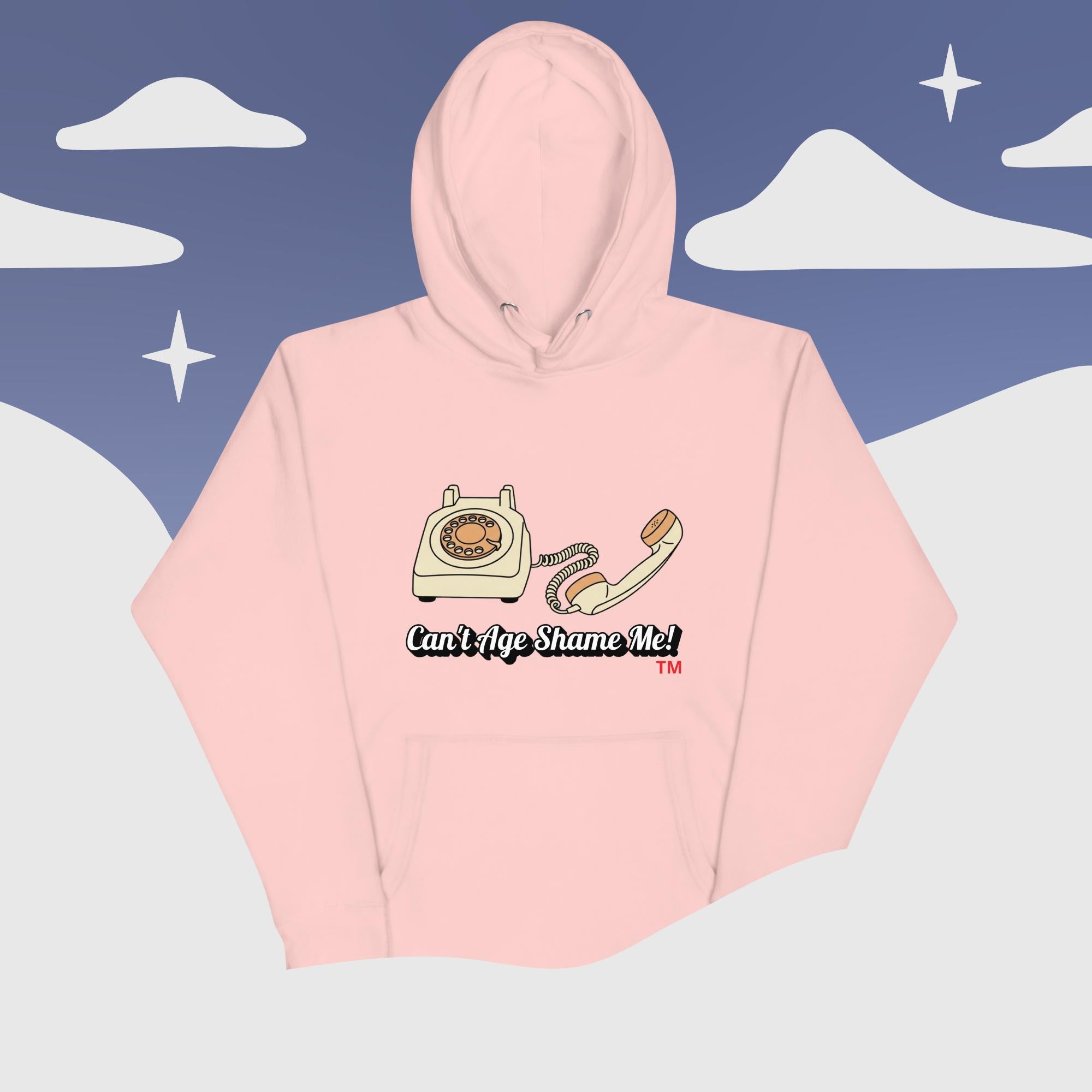 Pink hoodie with phone graphic and text 'Can't Age Shame Me!' on a stylized landscape background