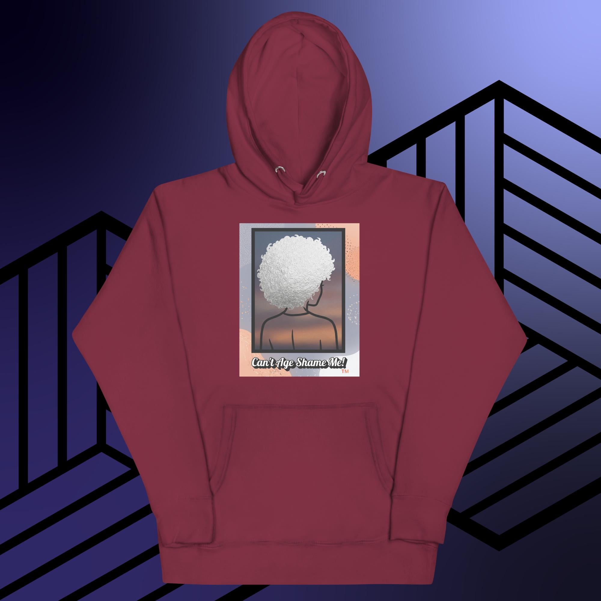 Maroon hoodie with a graphic design of a person with textured hair and text 'Can't Age Shame Me!' on a colorful background.


