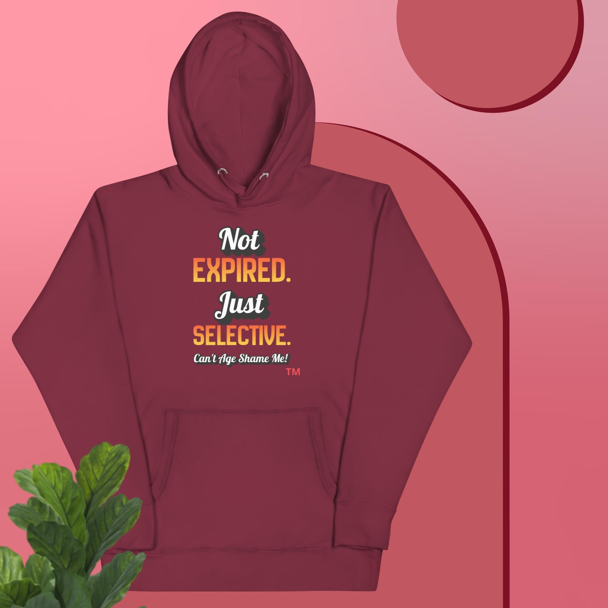 Maroon hoodie with text design on a pink background