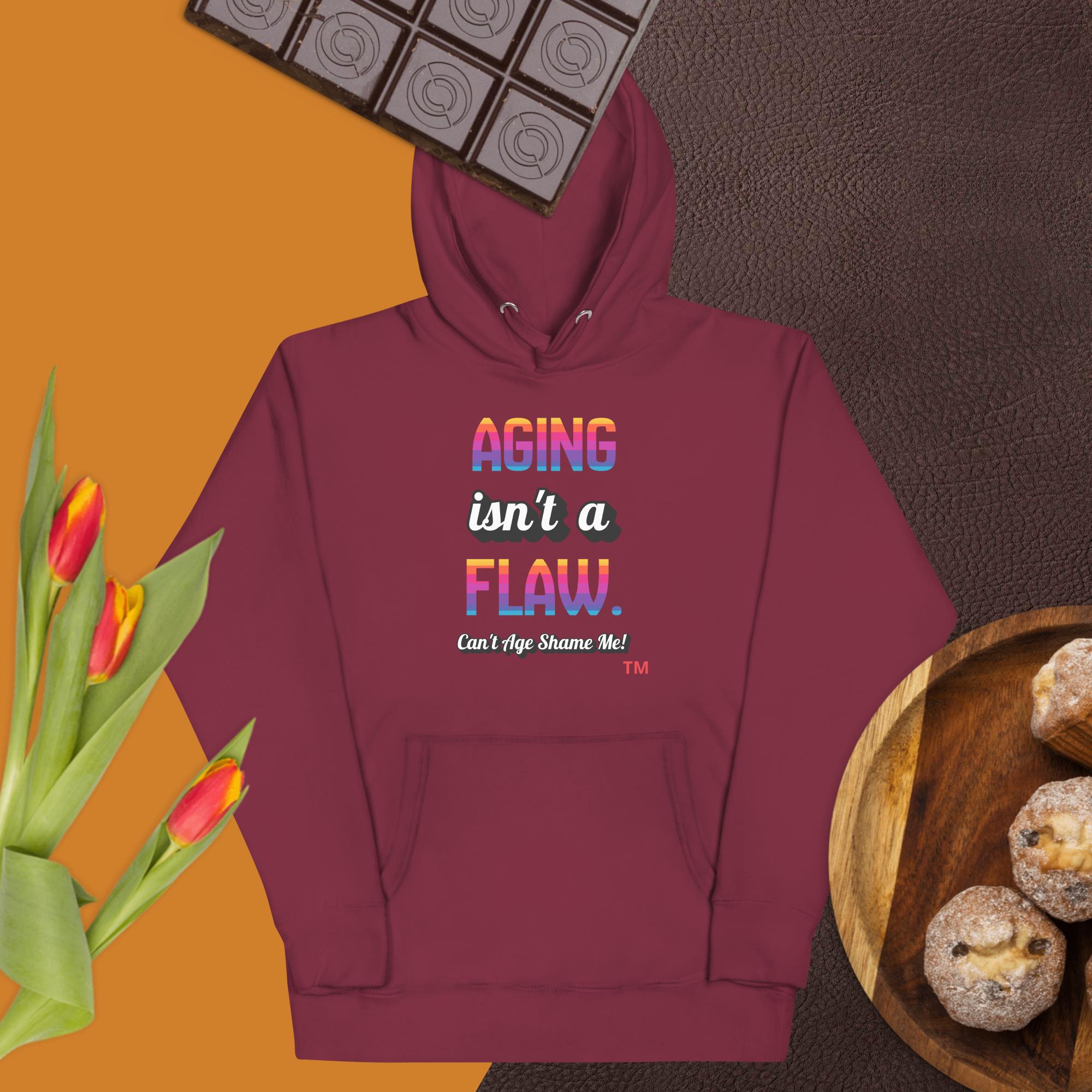 Maroon hoodie with colorful text on a brown background with flowers and cookies.