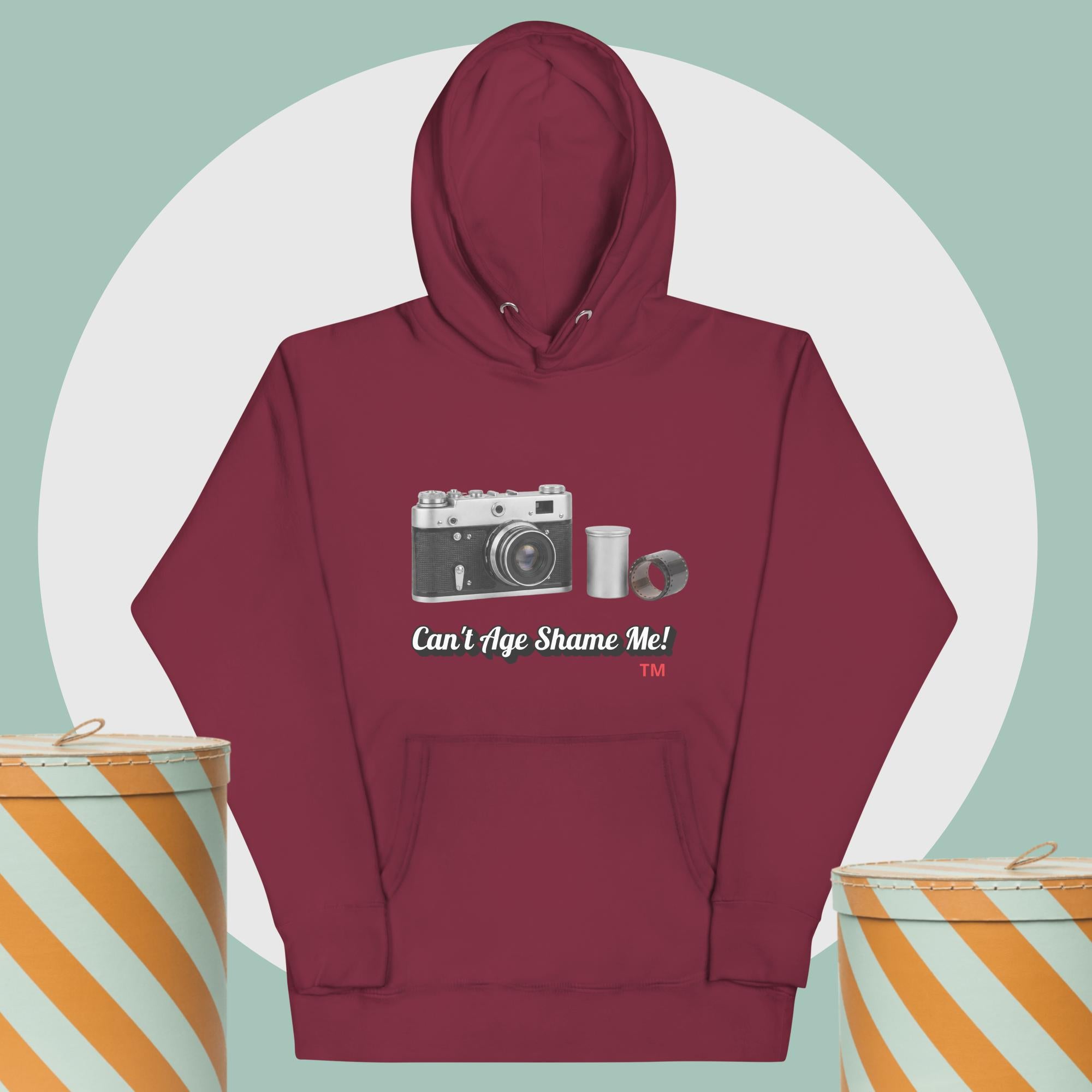 Maroon hoodie with camera graphic background two yellow and white hat boxes