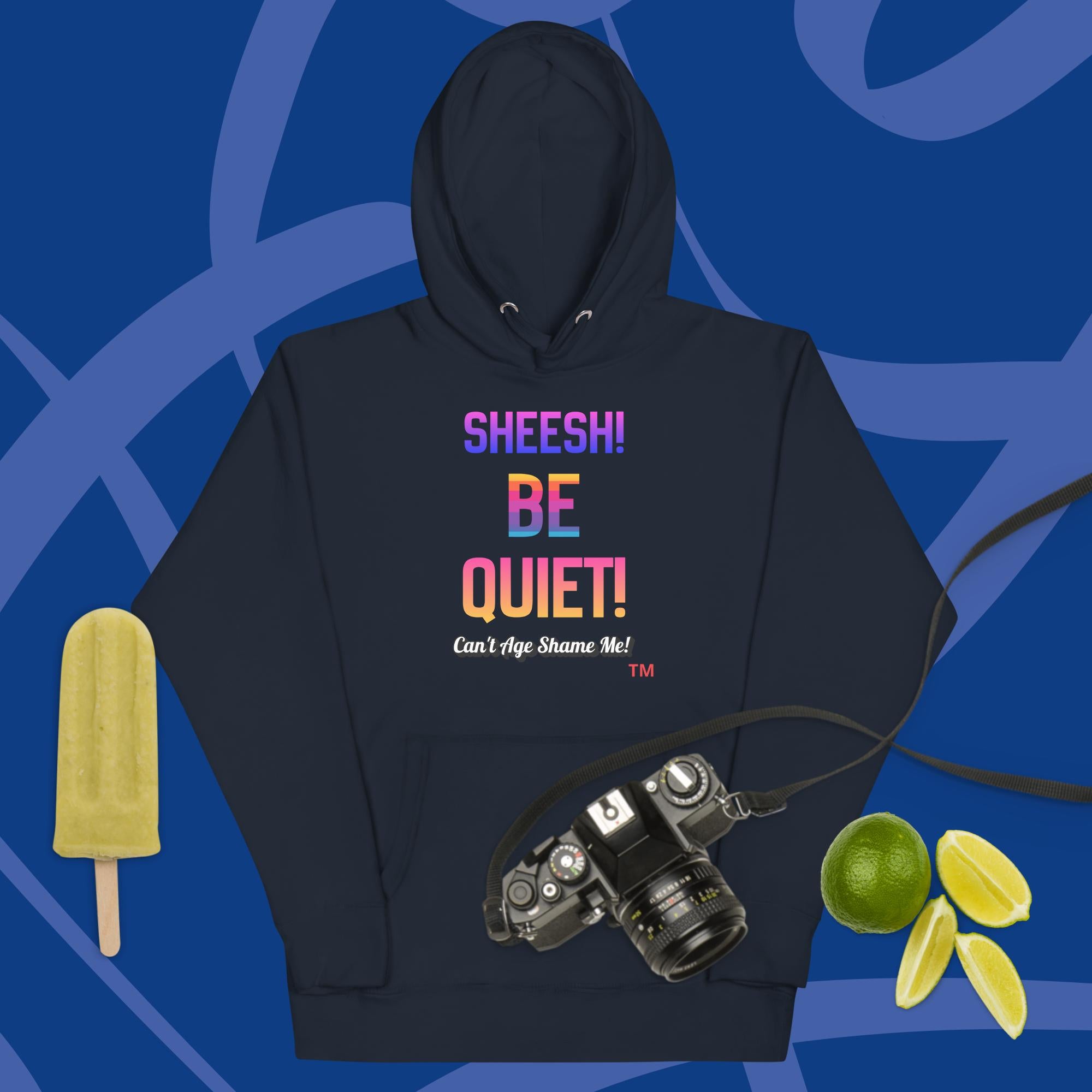 Navy hoodie with colorful text: Sheesh! Be Quiet! 'Can't Age Shame Me!  on a blue background with camera, popsicle, and limes.


