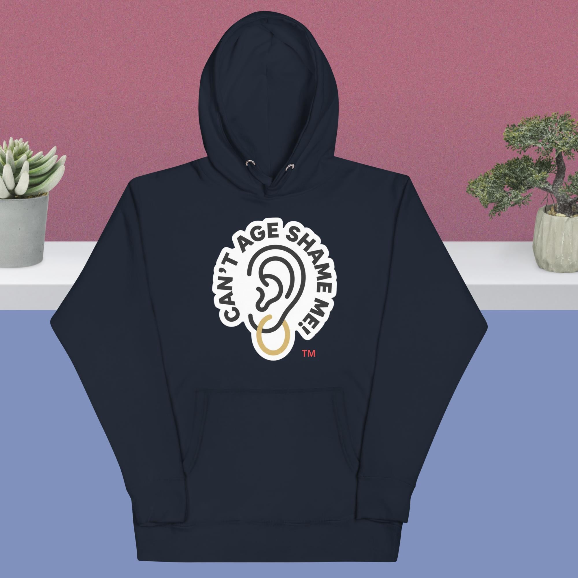 Navy hoodie with 'Can't Age Shame Me' design on a blue and pink gradient background