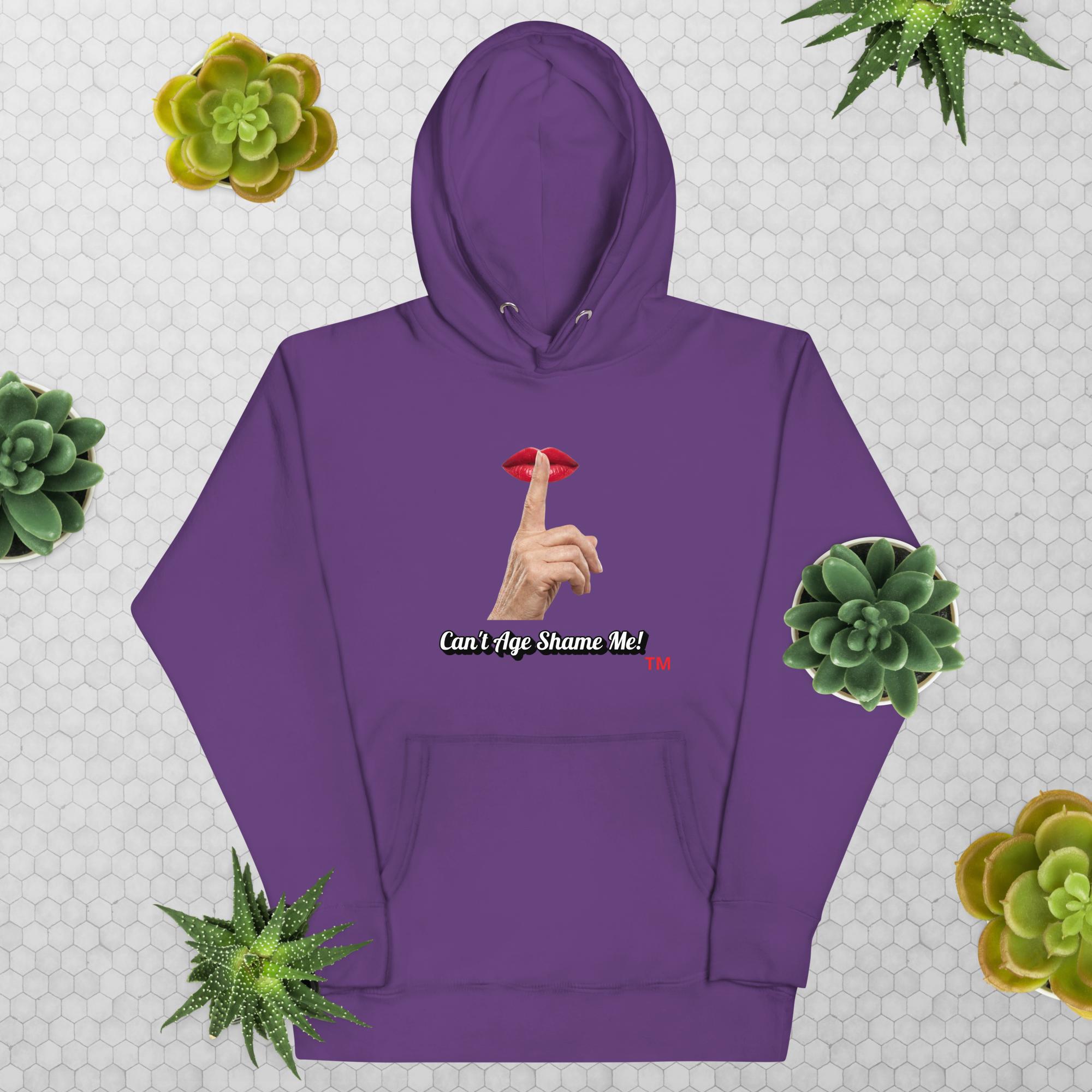 Purple hoodie with graphic design and text, Can’t Age Shame Me!, on a patterned background with succulents