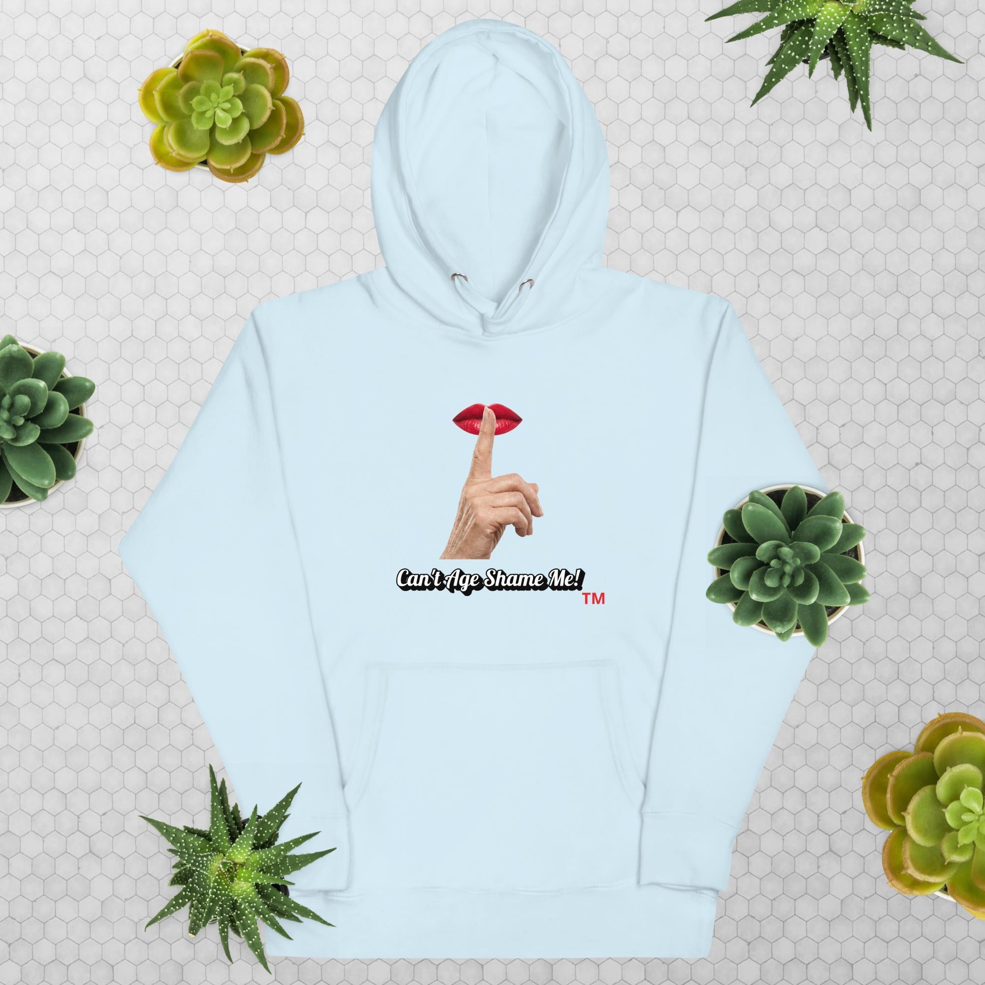 Sky Blue hoodie with graphic design and text, Can’t Age Shame Me!, on a patterned background with succulents