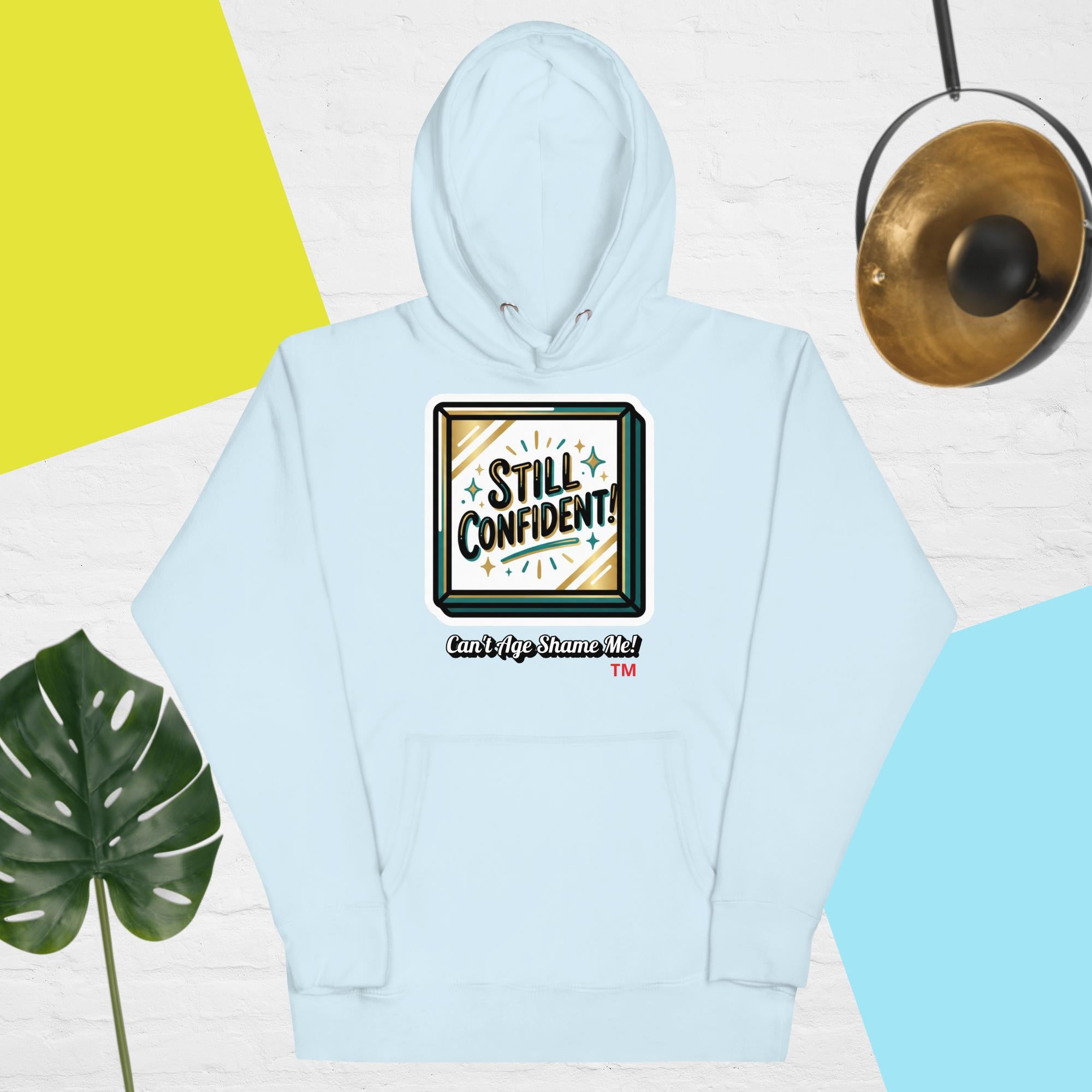 Light blue hoodie with 'Still Confident' graphic on a colorful background