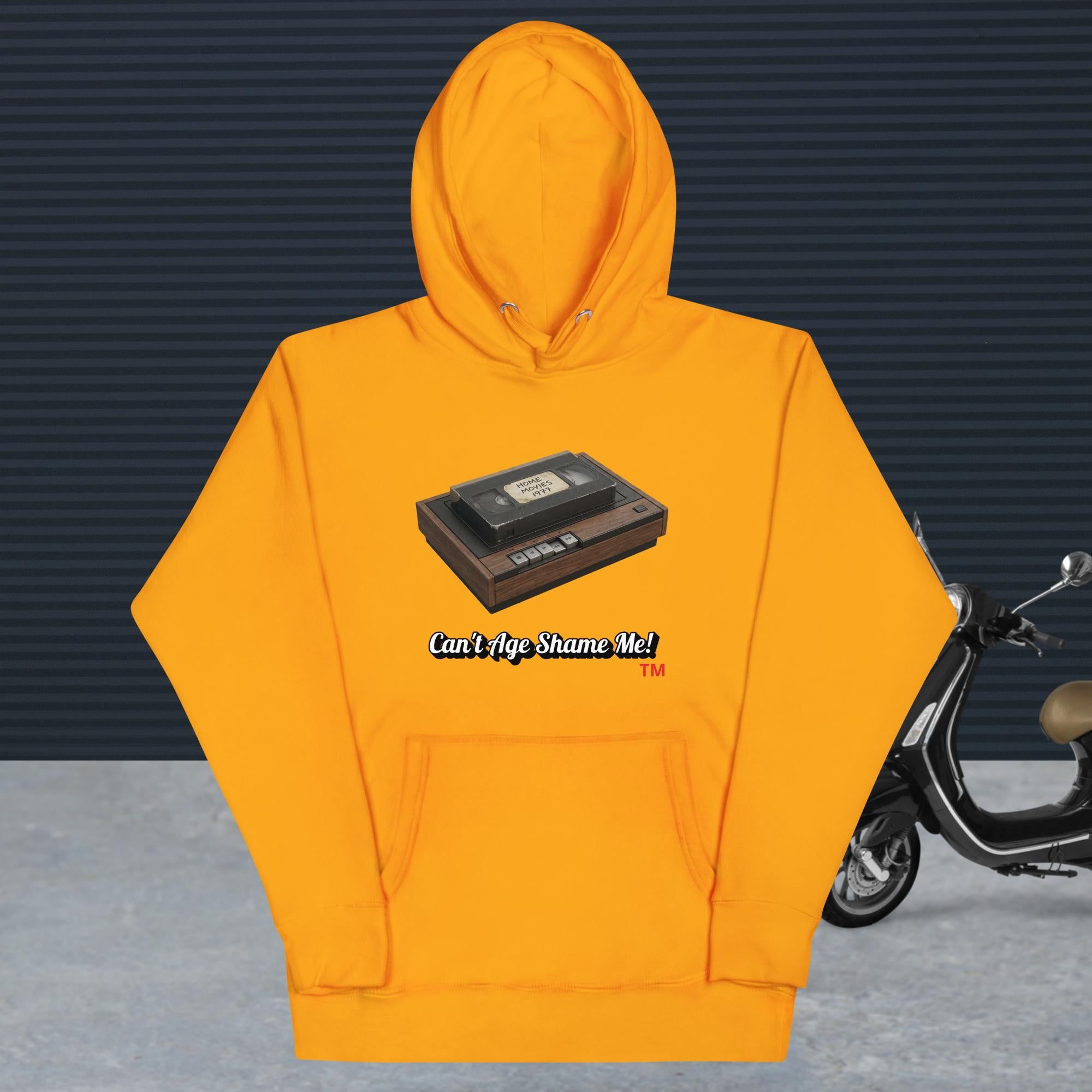 gold hoodie with a design of vhs recorder and tape