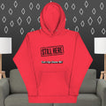 Red hoodie with text on a gray couch and patterned wall background