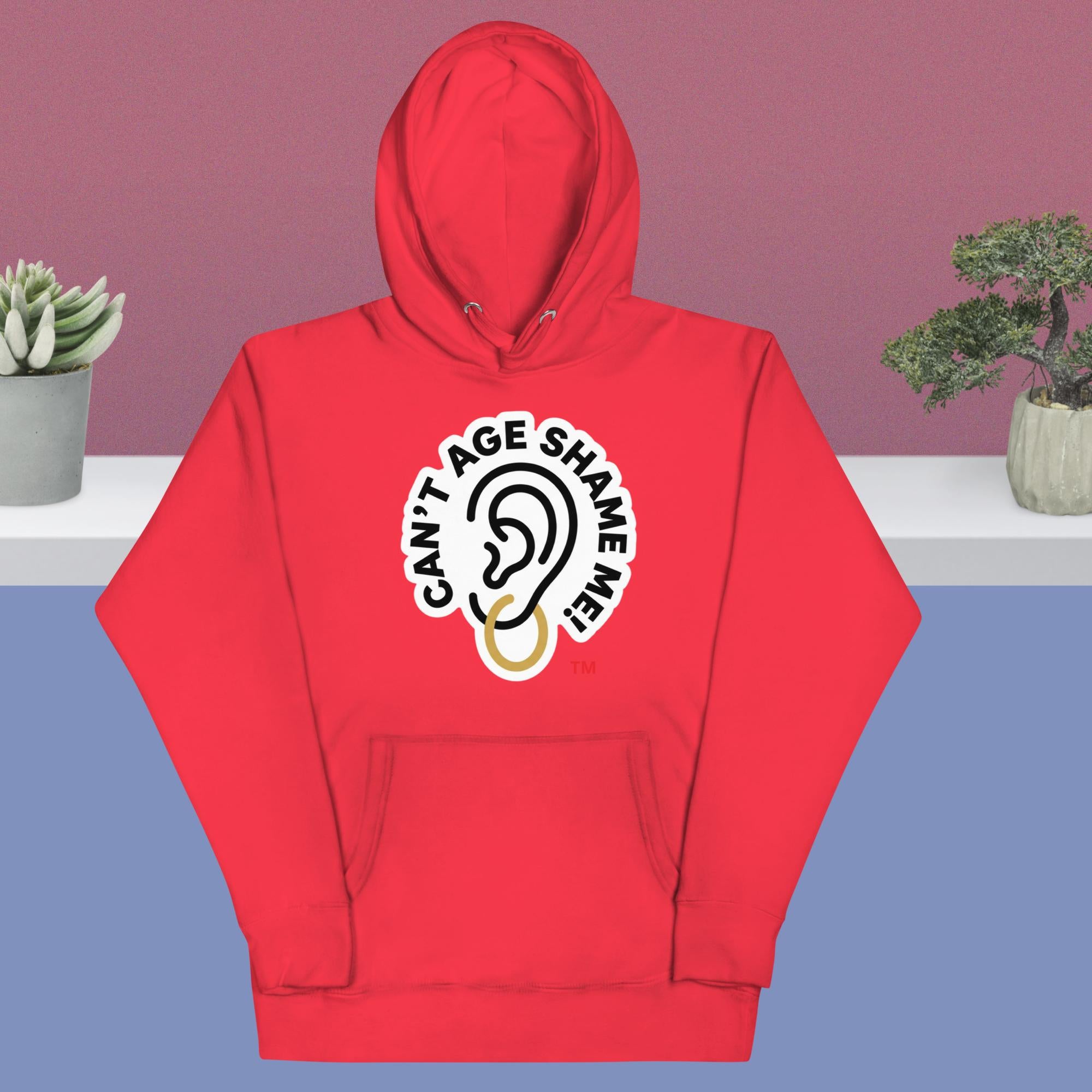 Team red hoodie with 'Can't Age Shame Me' design on a blue and pink gradient background