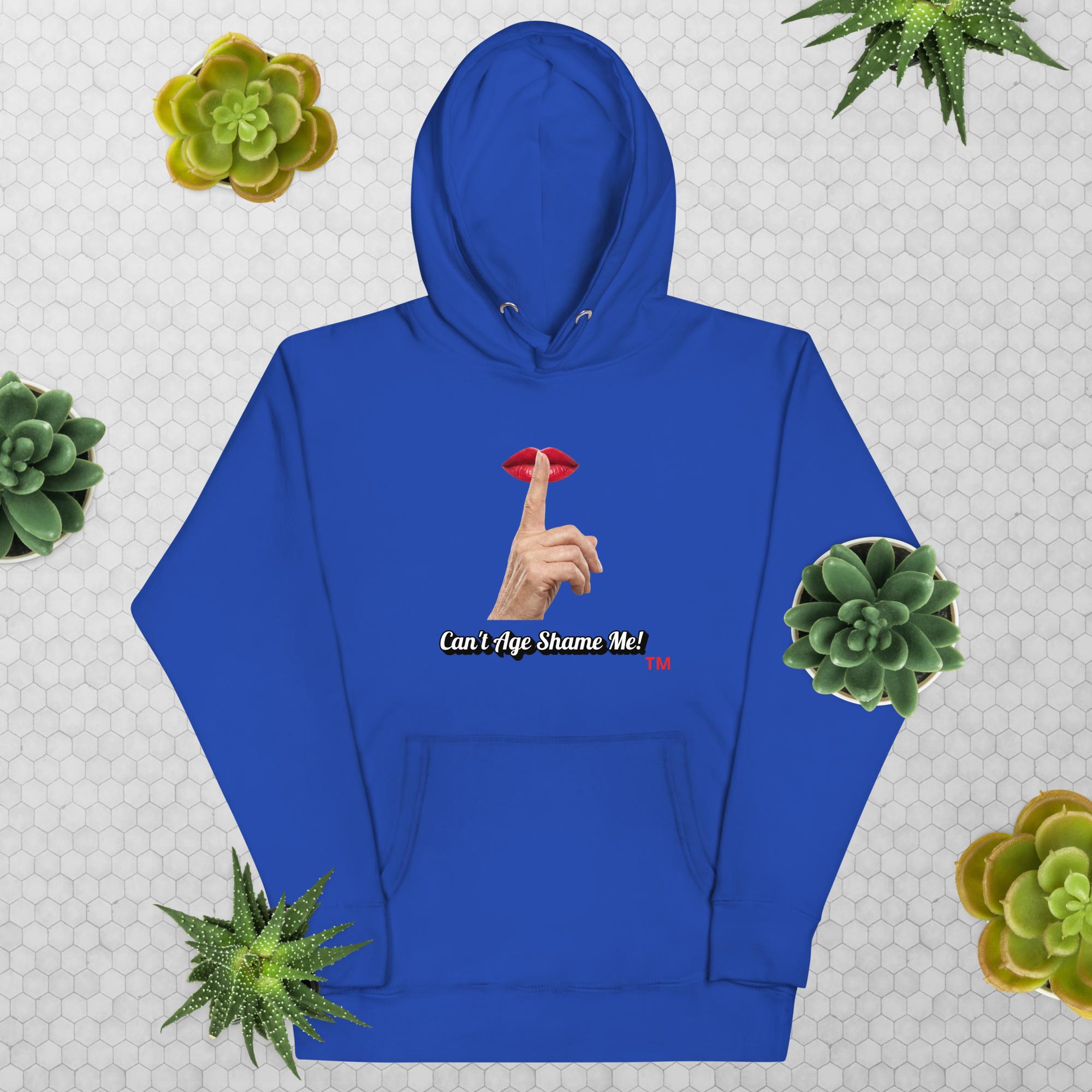 Team Royal hoodie with graphic design and text, Can’t Age Shame Me!, on a patterned background with succulents