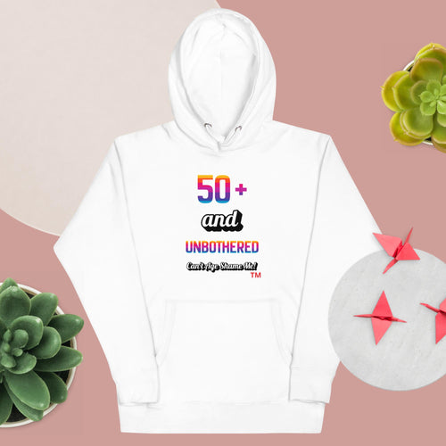 White hoodie with colorful text on a pink background with plants