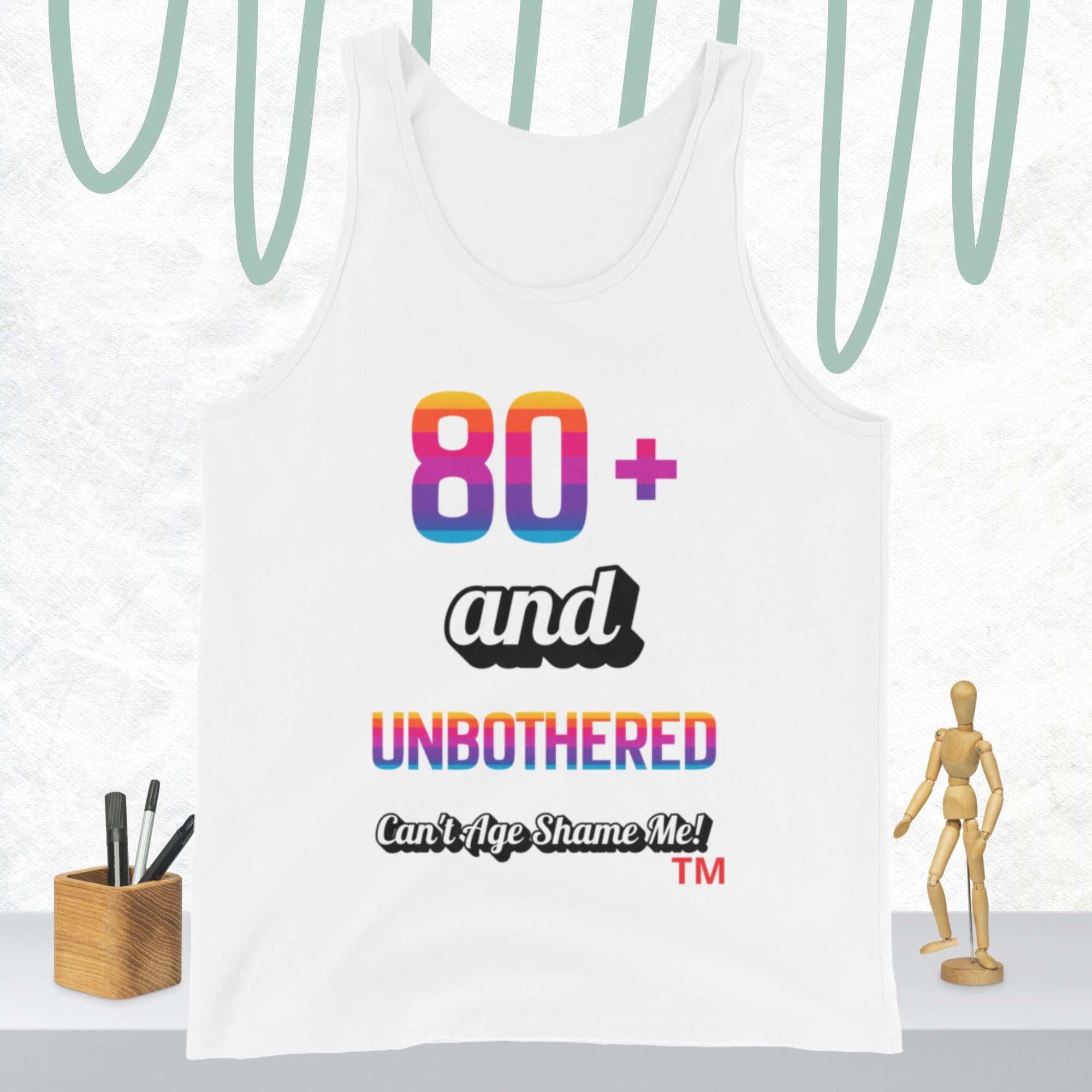 White tank top with colorful text  80+ and Unbothered Can't Age Shame Me! design on a white background.