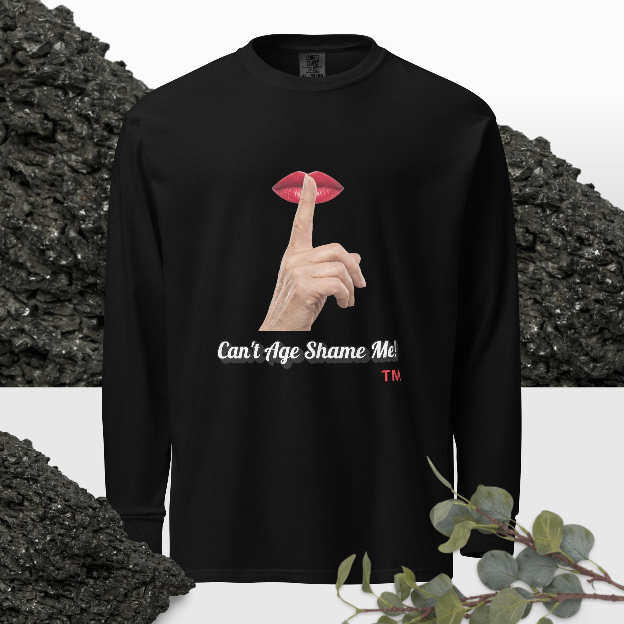 Black long-sleeve shirt with graphic design of finger on mouth and text 'Can't Age Shame Me' on a textured background.