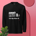 Black long sleeve shirt with camera graphic and text  can't age shame me on a pink background