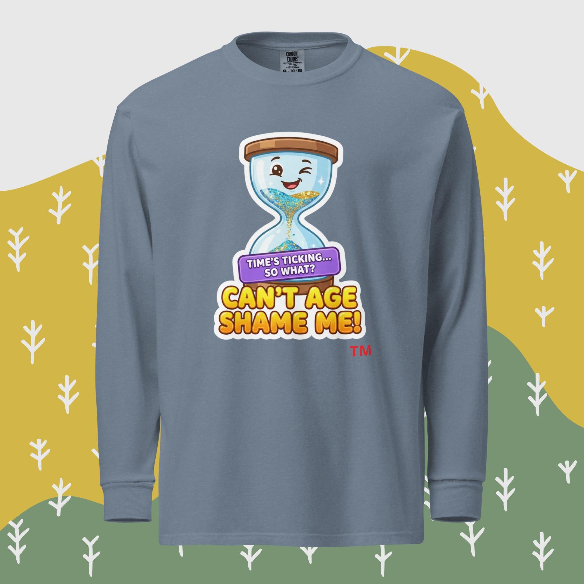 Blue Jean  long-sleeve shirt with a cartoon hourglass design and text 'Can't Age Shame Me' graphic on a patterned background

