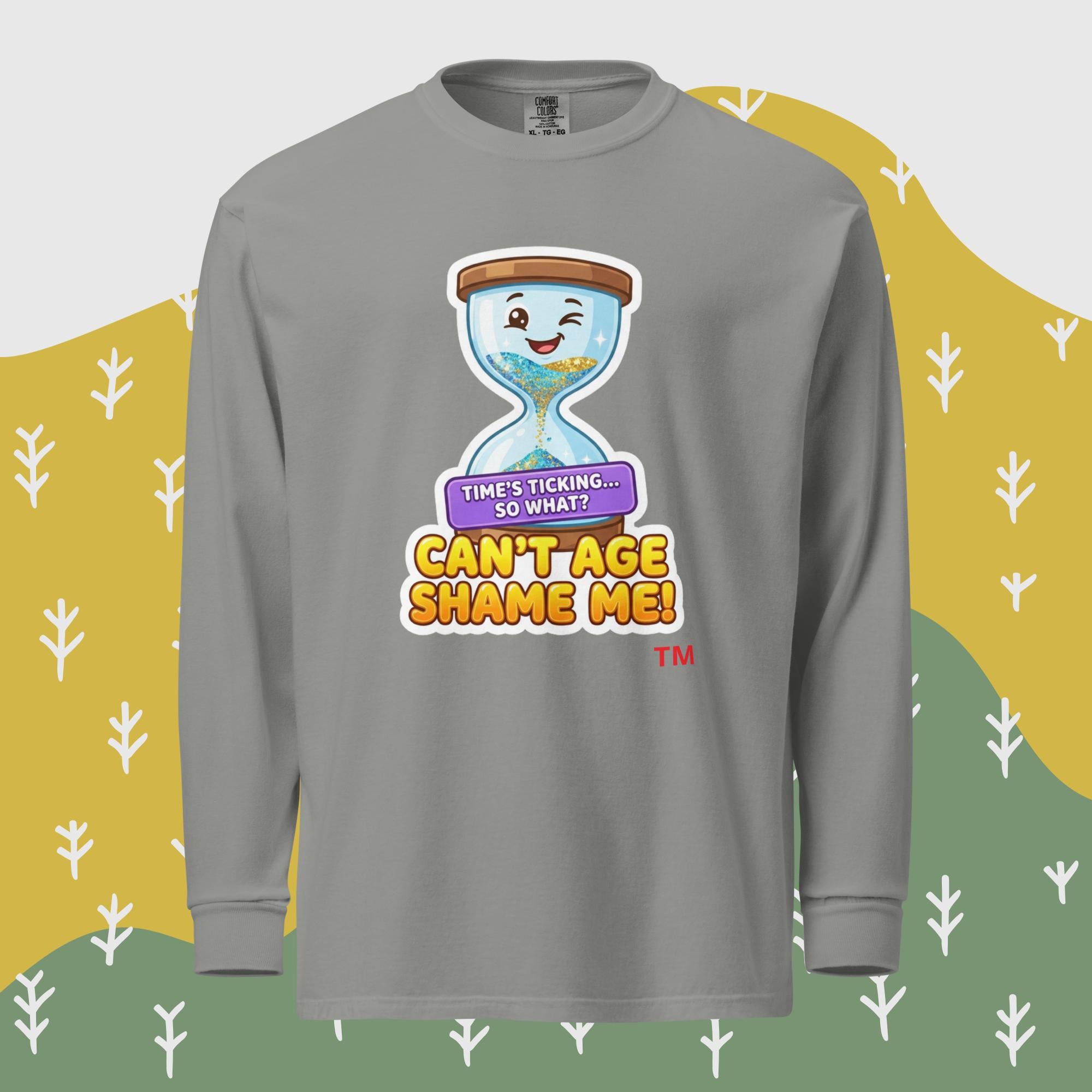 Gray long-sleeve shirt with a cartoon hourglass design and text 'Can't Age Shame Me' graphic on a patterned background

