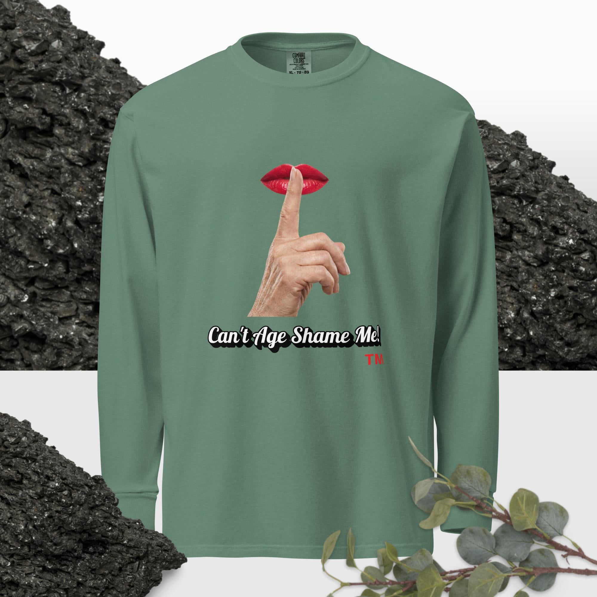 Light Green long-sleeve shirt with graphic design of finger on mouth and text 'Can't Age Shame Me' on a textured background.