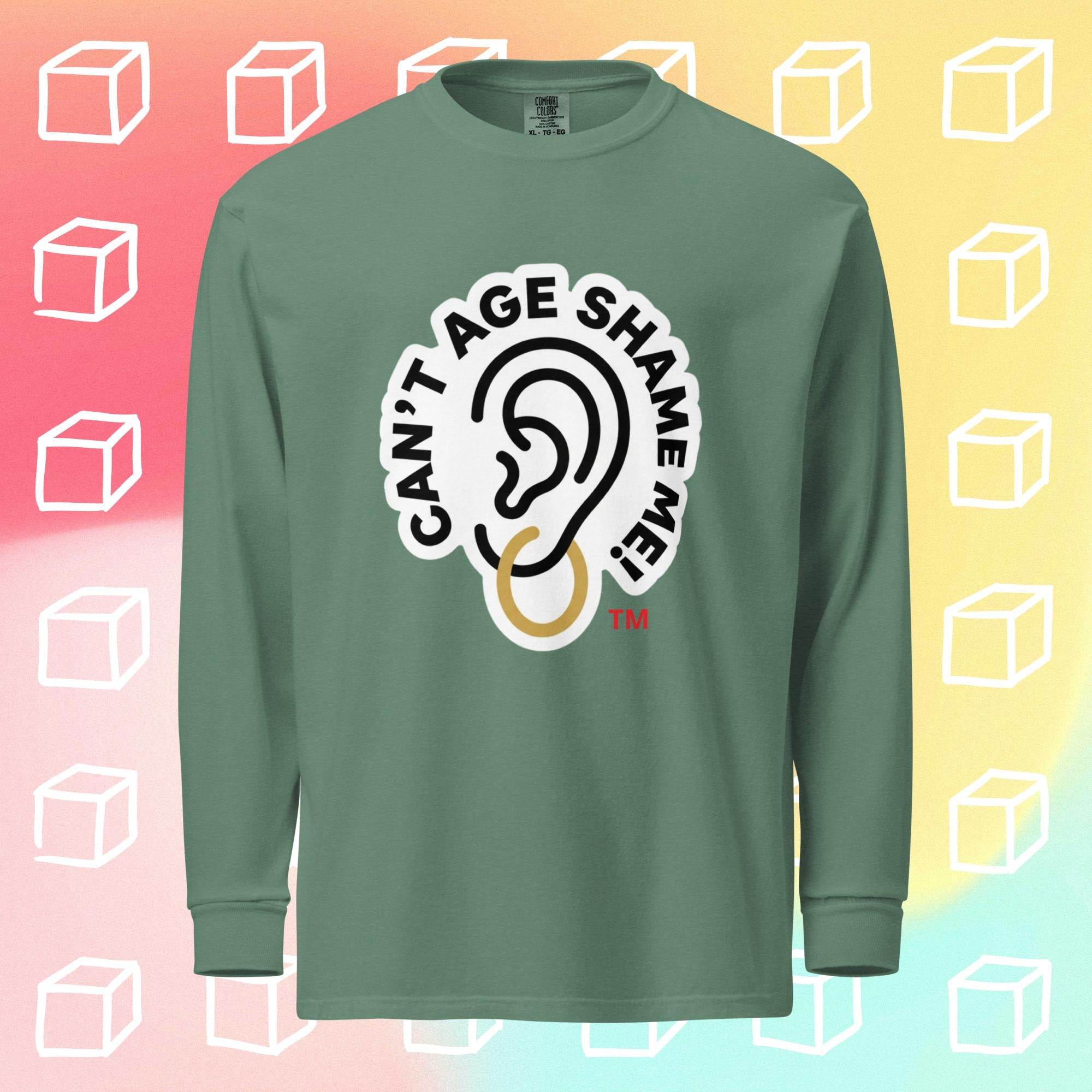 Green long-sleeve shirt with 'Can't Age Shame Me' graphic on a colorful background with white cube shapes.