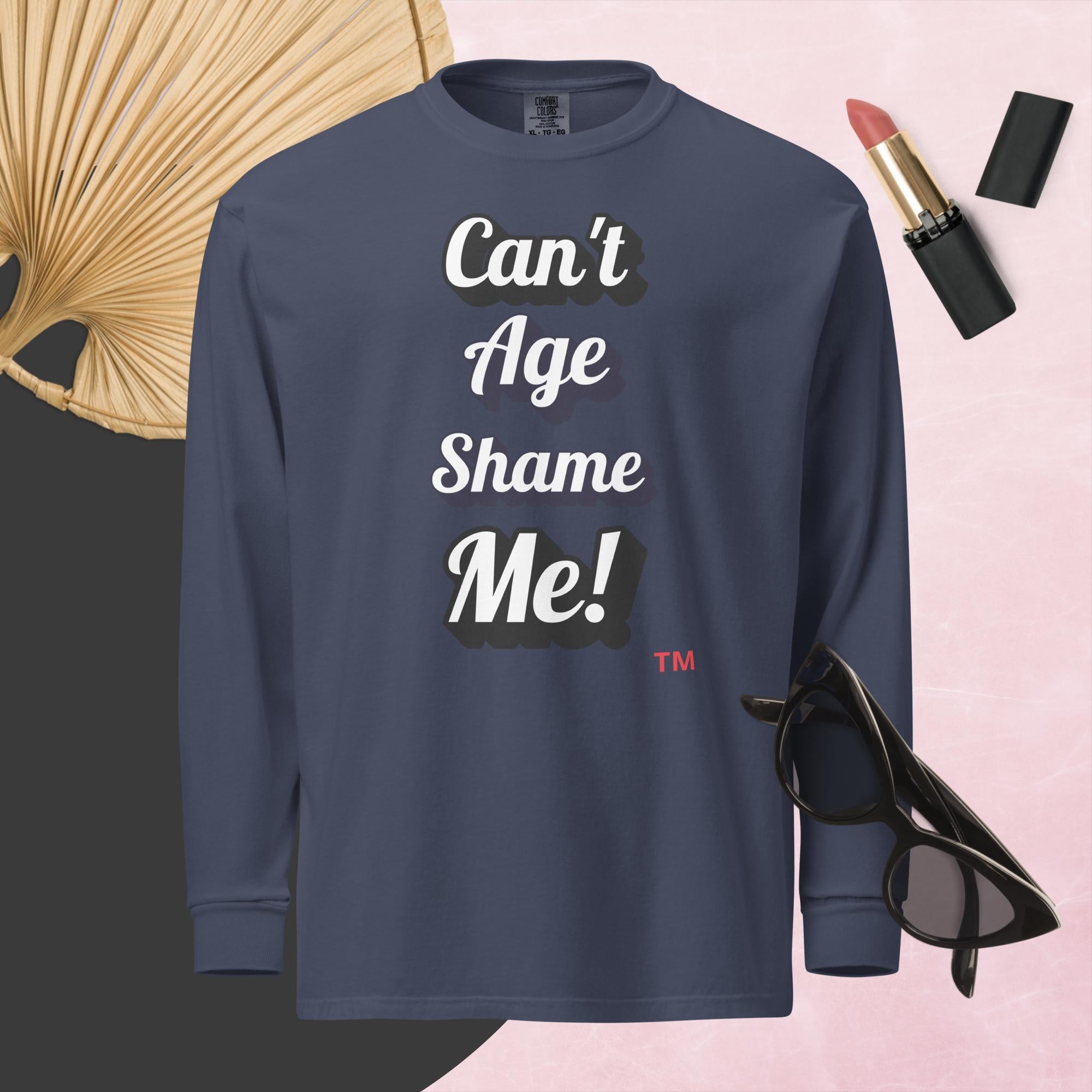 Navy blue sweatshirt with 'Can't Age Shame Me!' text on a pink background with accessories.