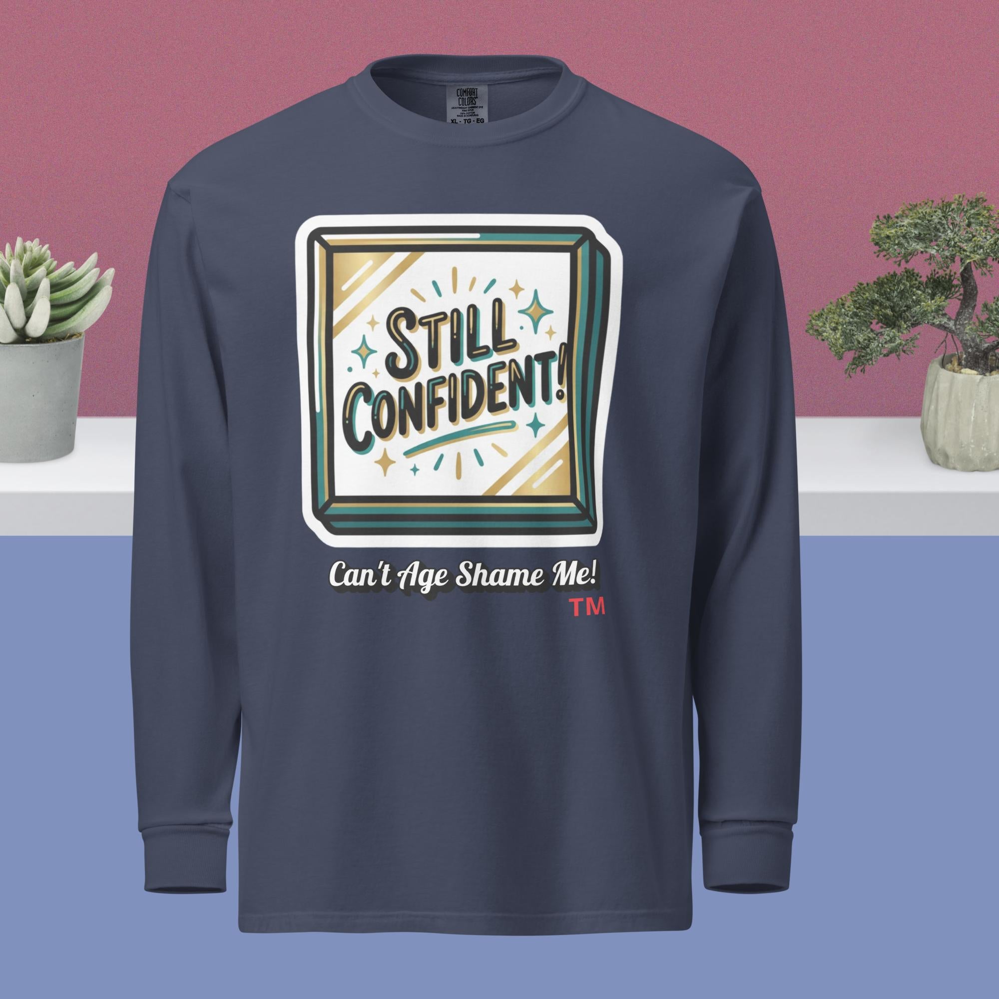 Navy long-sleeve shirt with 'Still Confident! Can't Age Shame Me!' design on a blue and pink gradient background.