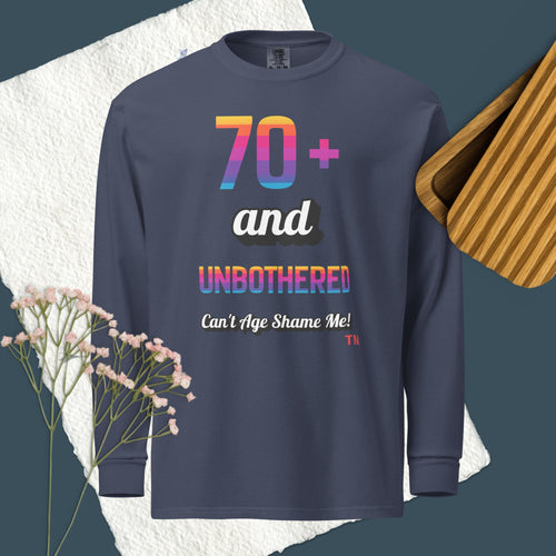 Navy long-sleeve shirt with colorful text design on a textured surface with flowers and wooden object.