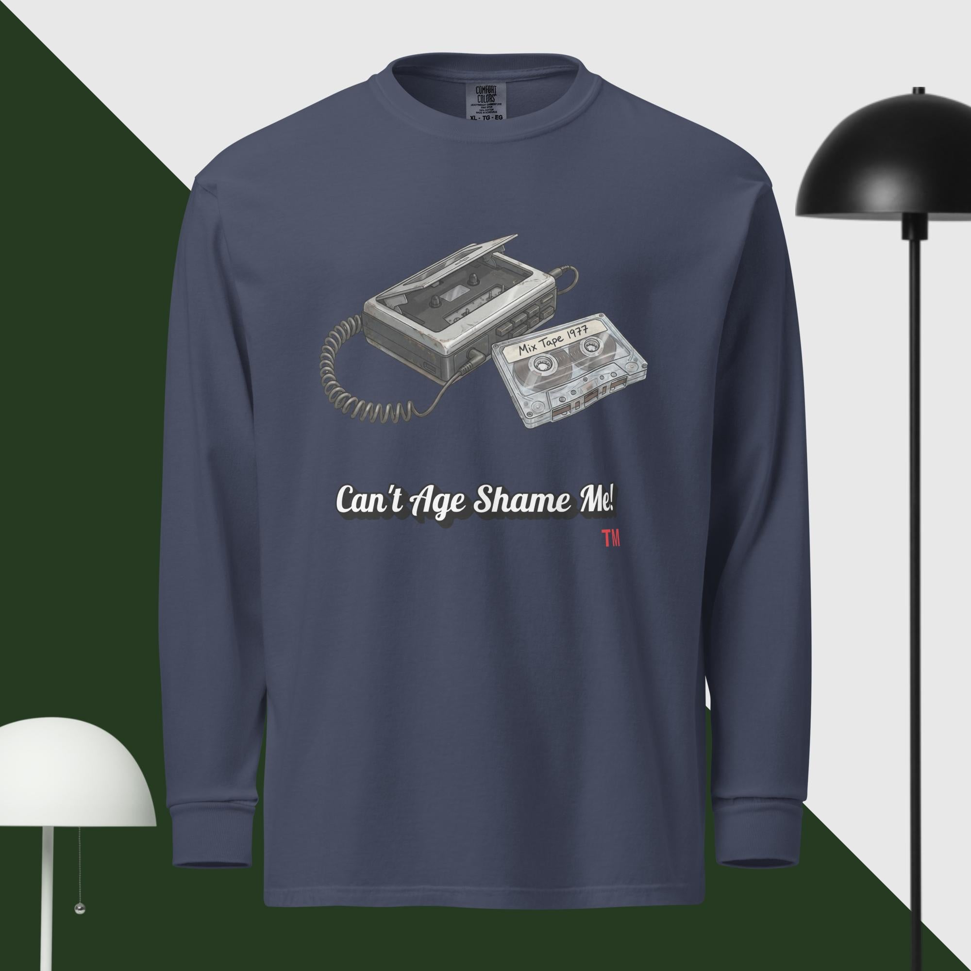 Navy blue long-sleeve shirt with cassette tape graphic and text 'Can't Age Shame Me' on a geometric background.