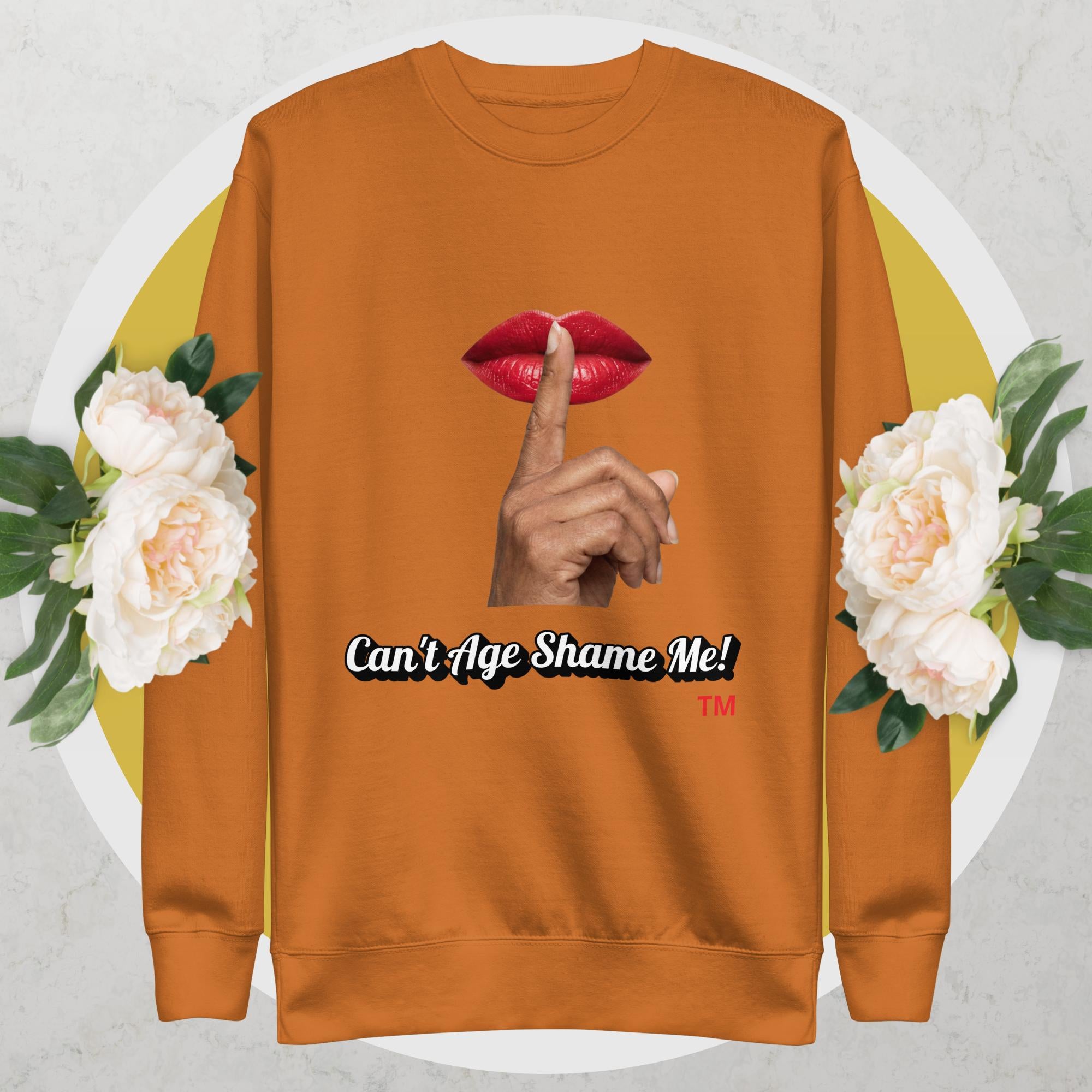 Adobe sweatshirt with graphic design of a hand, lips, and text 'Can't Age Shame Me!' on a floral background.