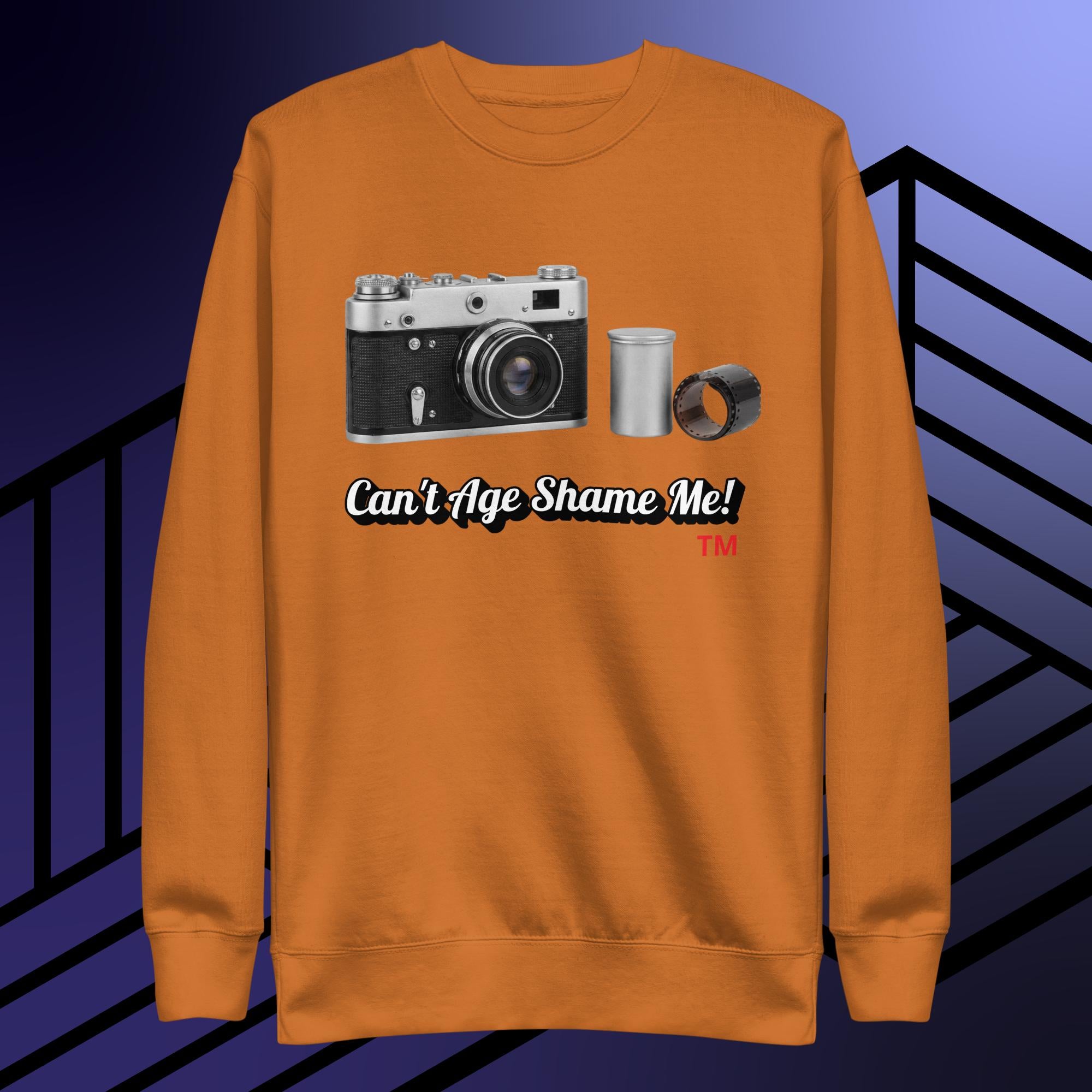 adobe sweatshirt with camera graphic and text 'Can't Age Shame Me!' on a blue and black striped background