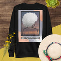 Black sweatshirt with a graphic design of a person with textured hair and text 'Can't Age Shame Me!' on a colorful background.