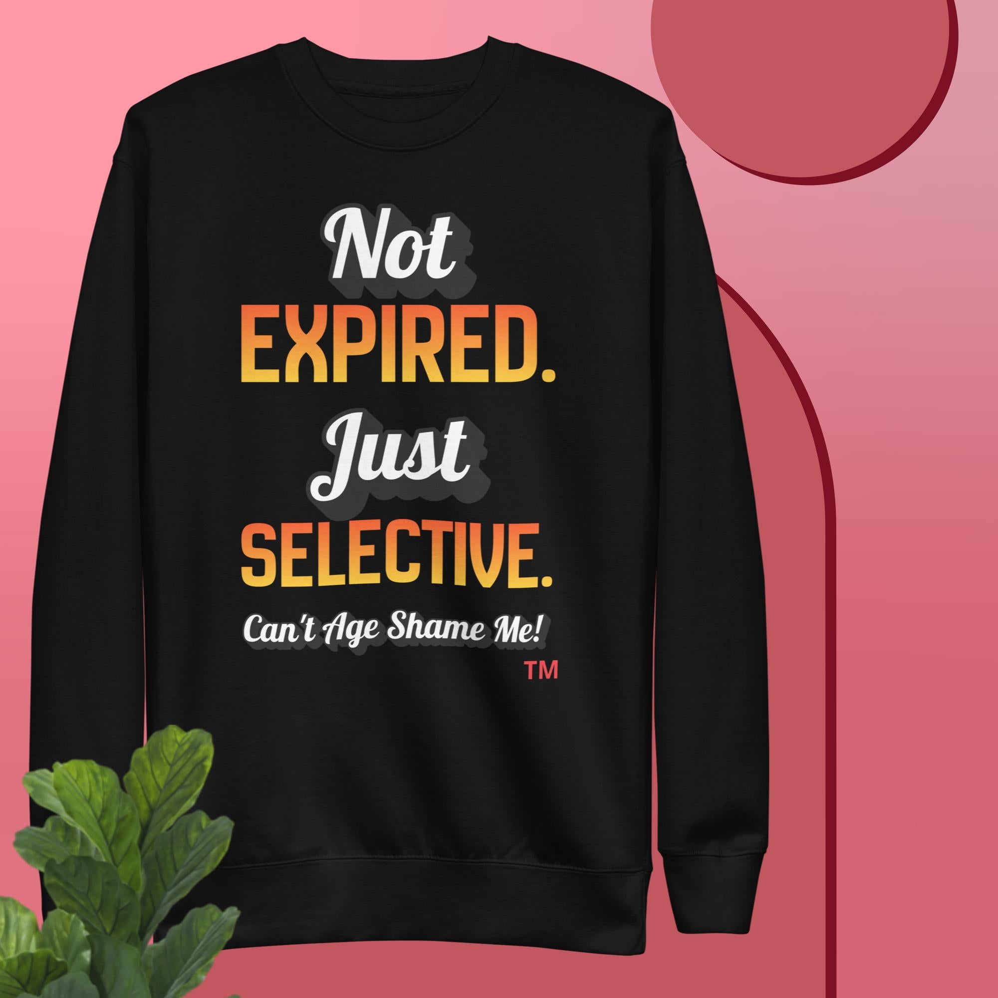 Black sweatshirt with colorful text on a pink background