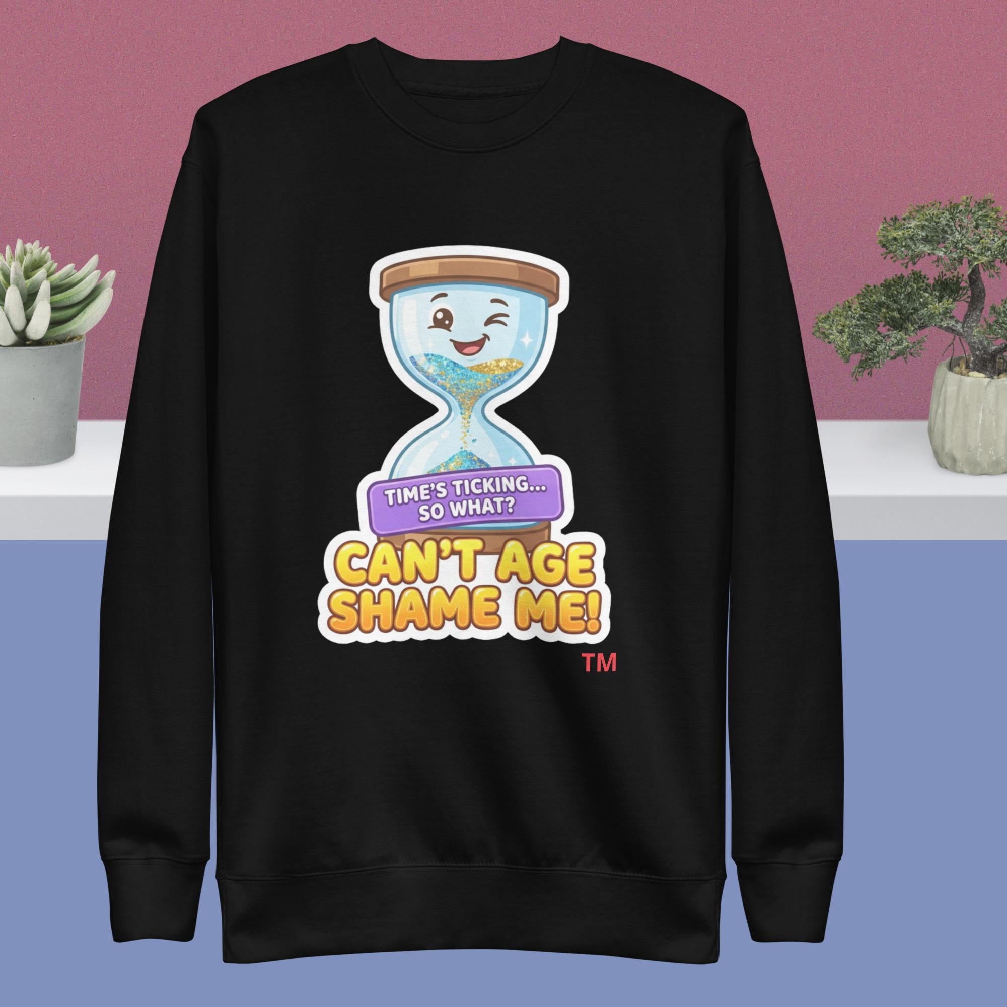 Black sweatshirt with a cartoon hourglass design and text on a pink and blue gradient background.