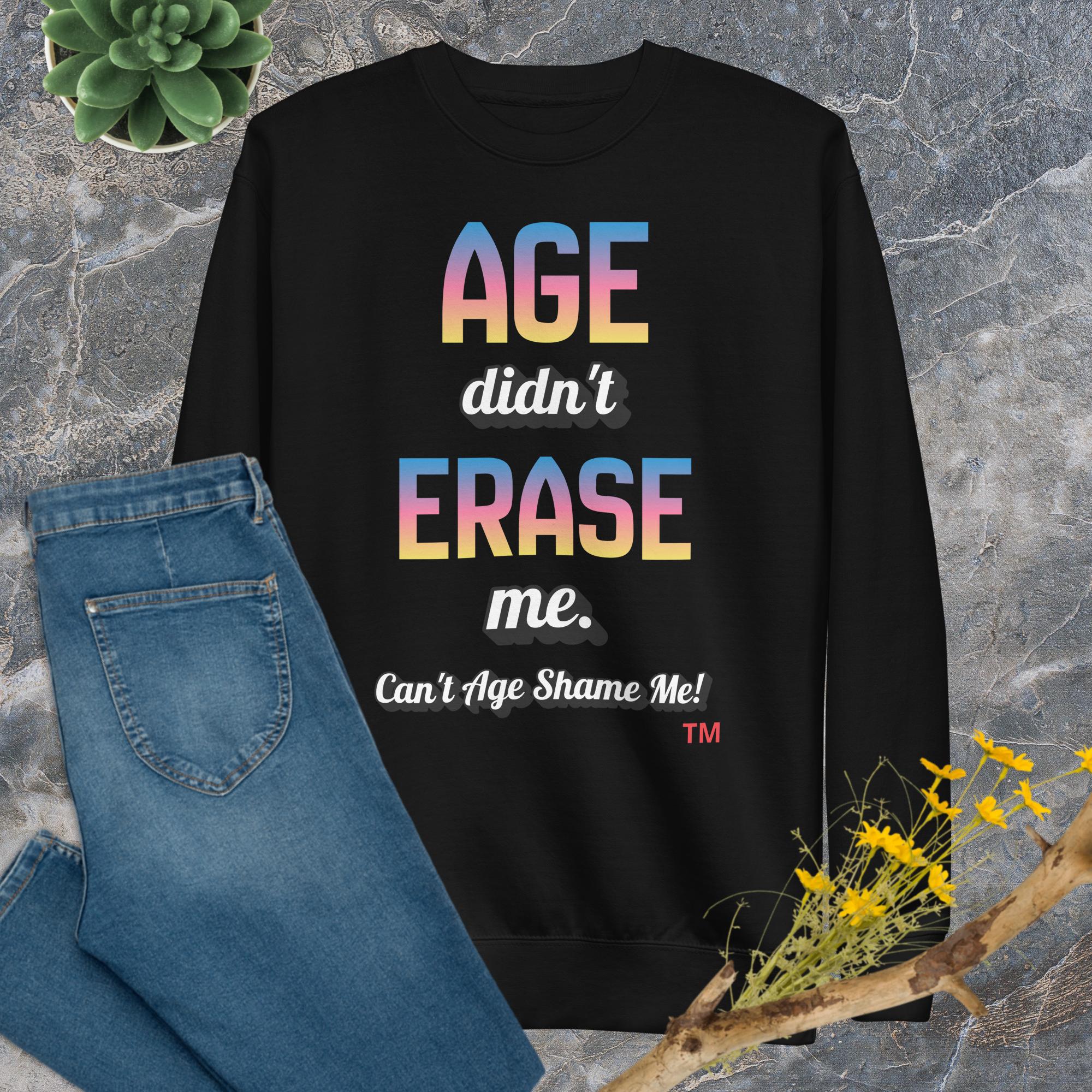 Black sweatshirt with colorful text on a stone surface with jeans and flowers.