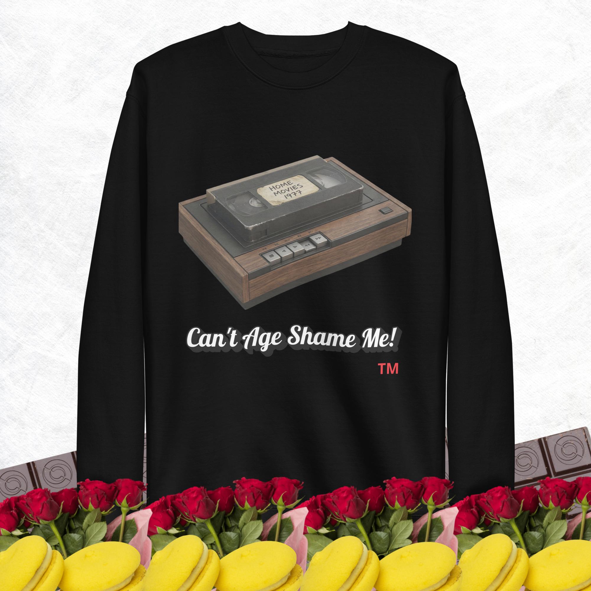 black sweatshirt with a vintage VHS player graphic and text 'Can't Age Shame Me!' on a white background.