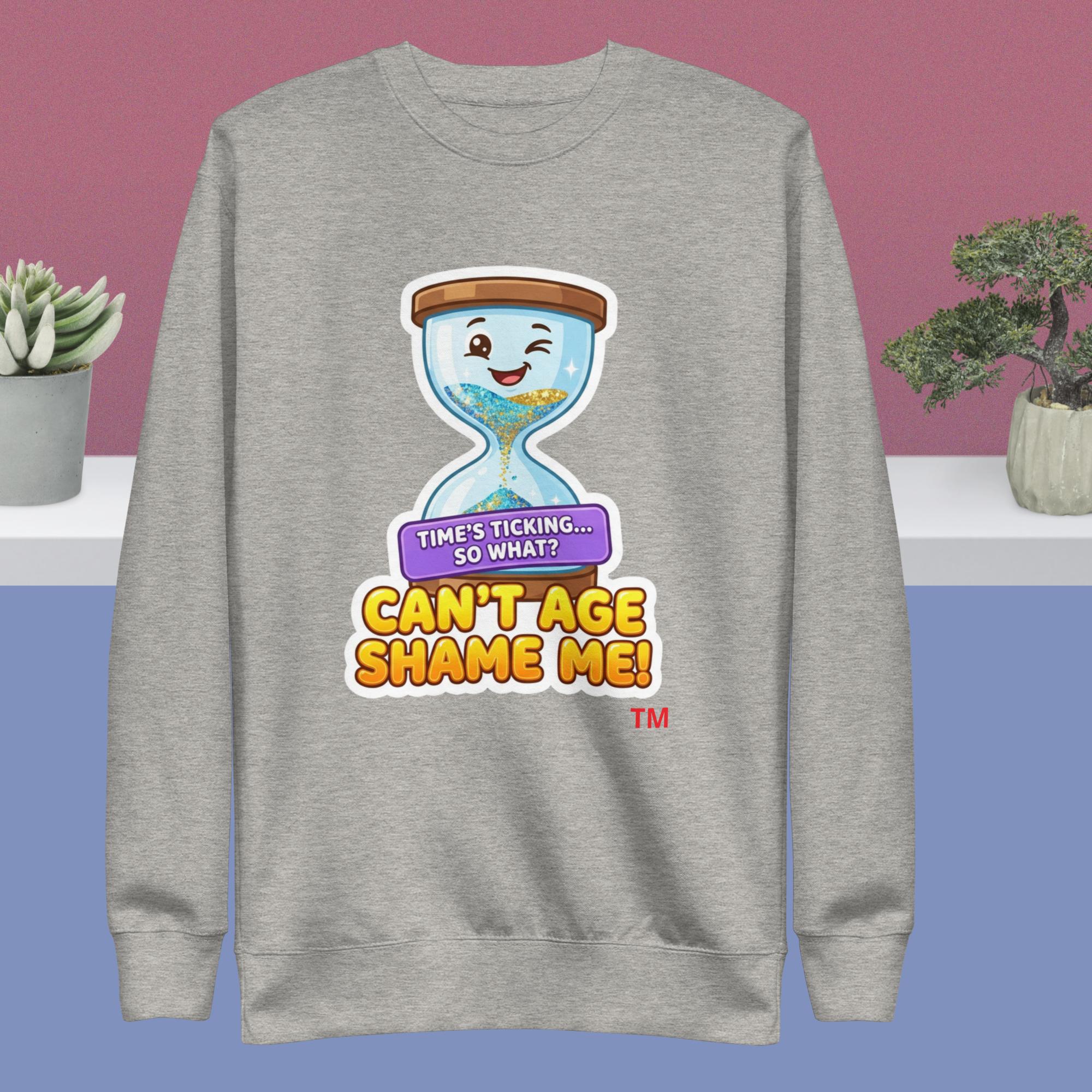 Gray sweatshirt with a cartoon hourglass design and humorous text on a pink and blue gradient background.