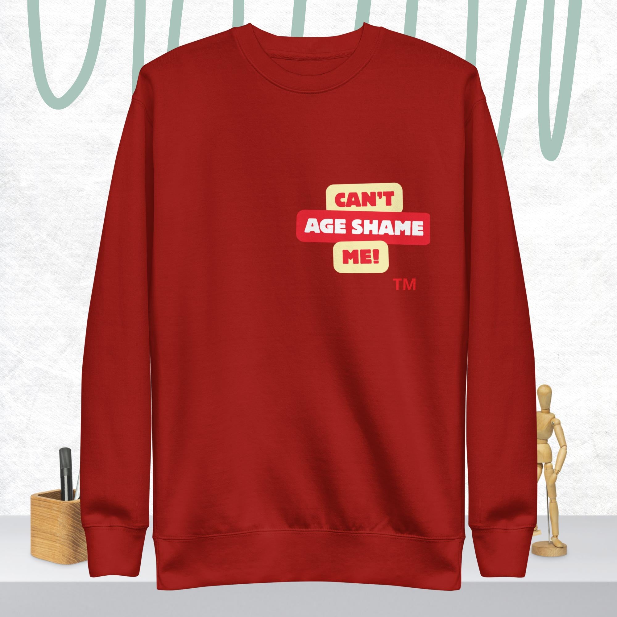 Cardinal Rose sweatshirt with 'CAN'T AGE SHAME ME!' text logo on a light gray background