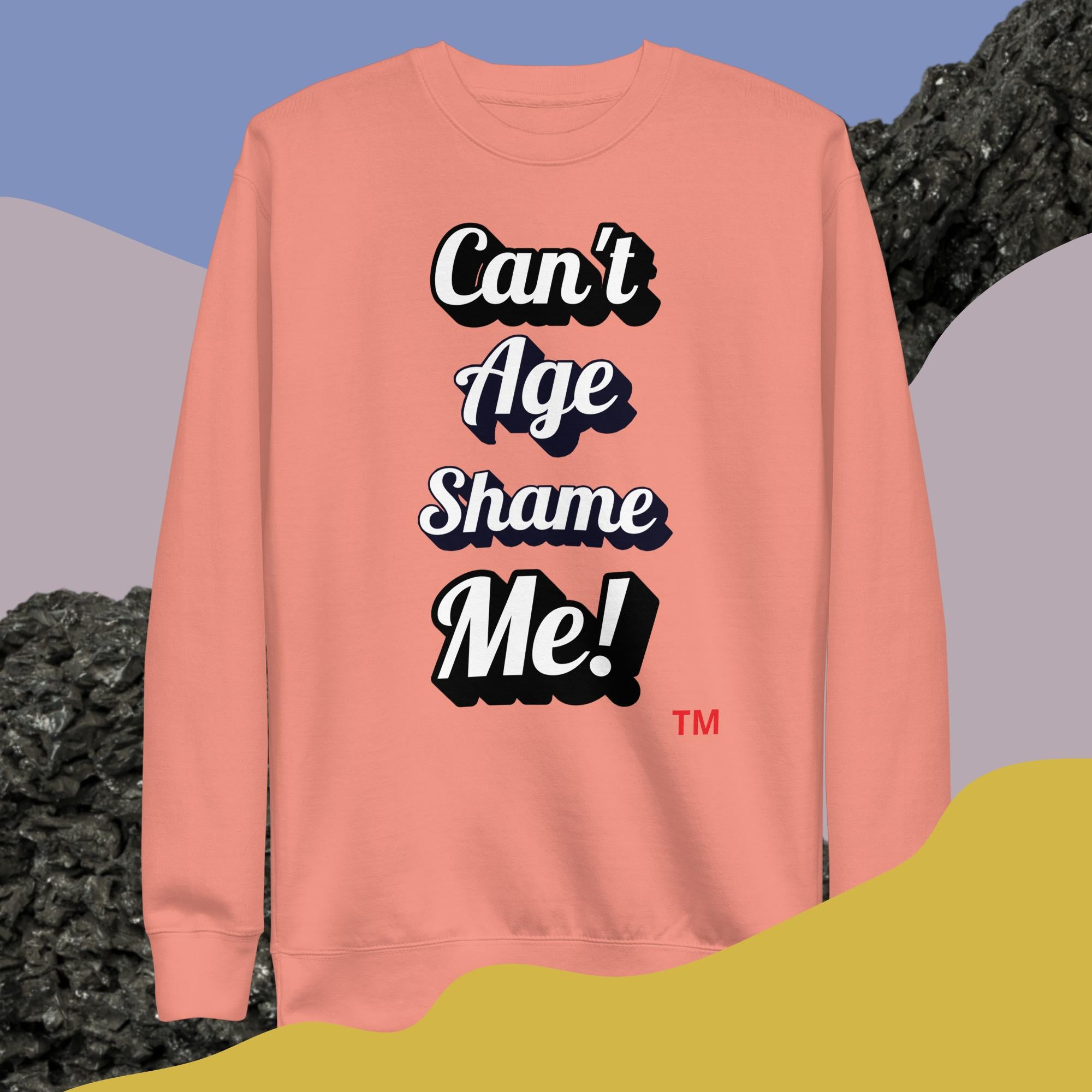 Pink sweatshirt with 'Can't Age Shame Me!' text on a colorful background