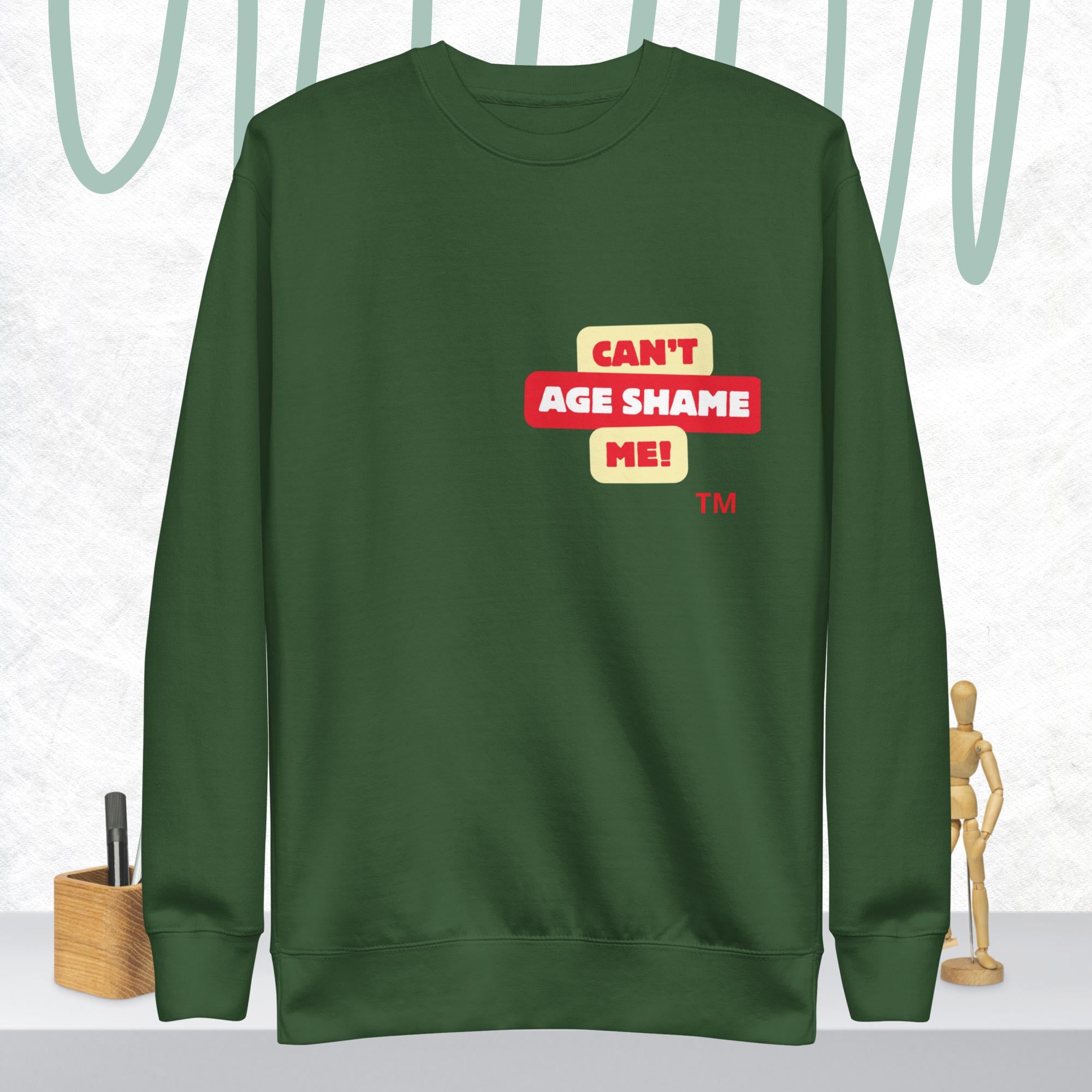 Forest Green sweatshirt with 'CAN'T AGE SHAME ME!' text logo on a light gray background